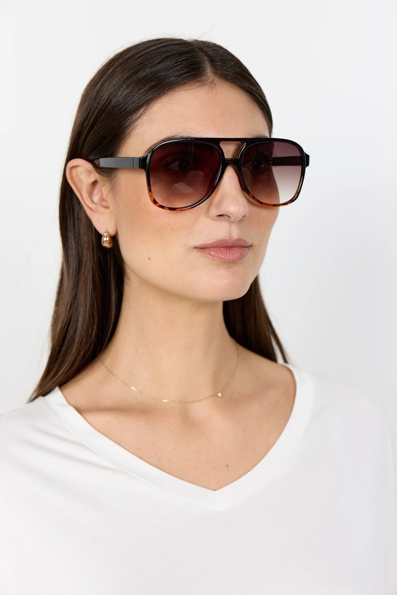 Woman wearing large sunglasses with a plain background