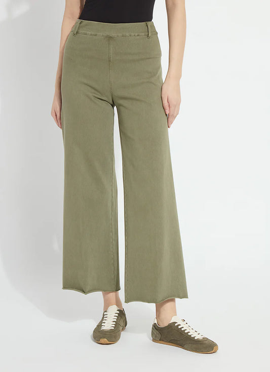 A model wearing a pair of olive green wide-leg cropped pants, styled with a black top and olive green sneakers against a plain white studio background.