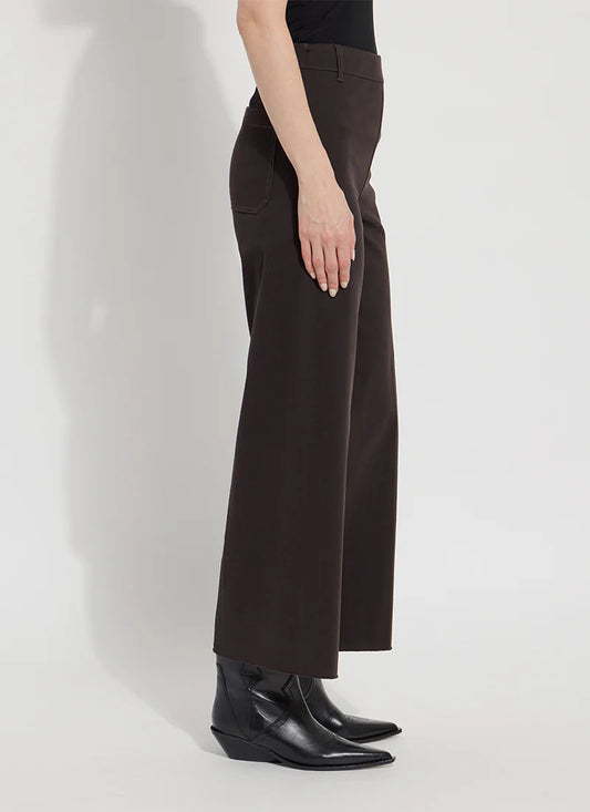 Person wearing dark brown wide-leg pants on a white background