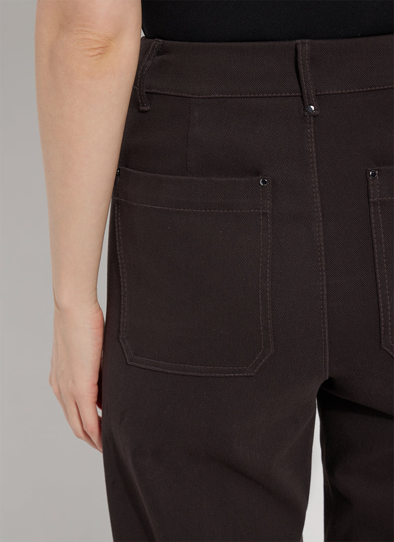 Close-up of the back waistband and rear pockets of dark brown pants worn by a model, showing the fabric texture and stitching details.