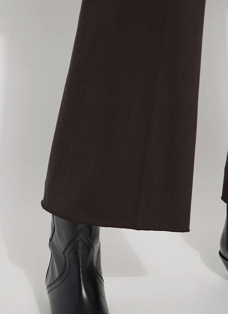 Close-up of dark brown wide-leg trousers paired with black leather western-style ankle boots on a white studio background.