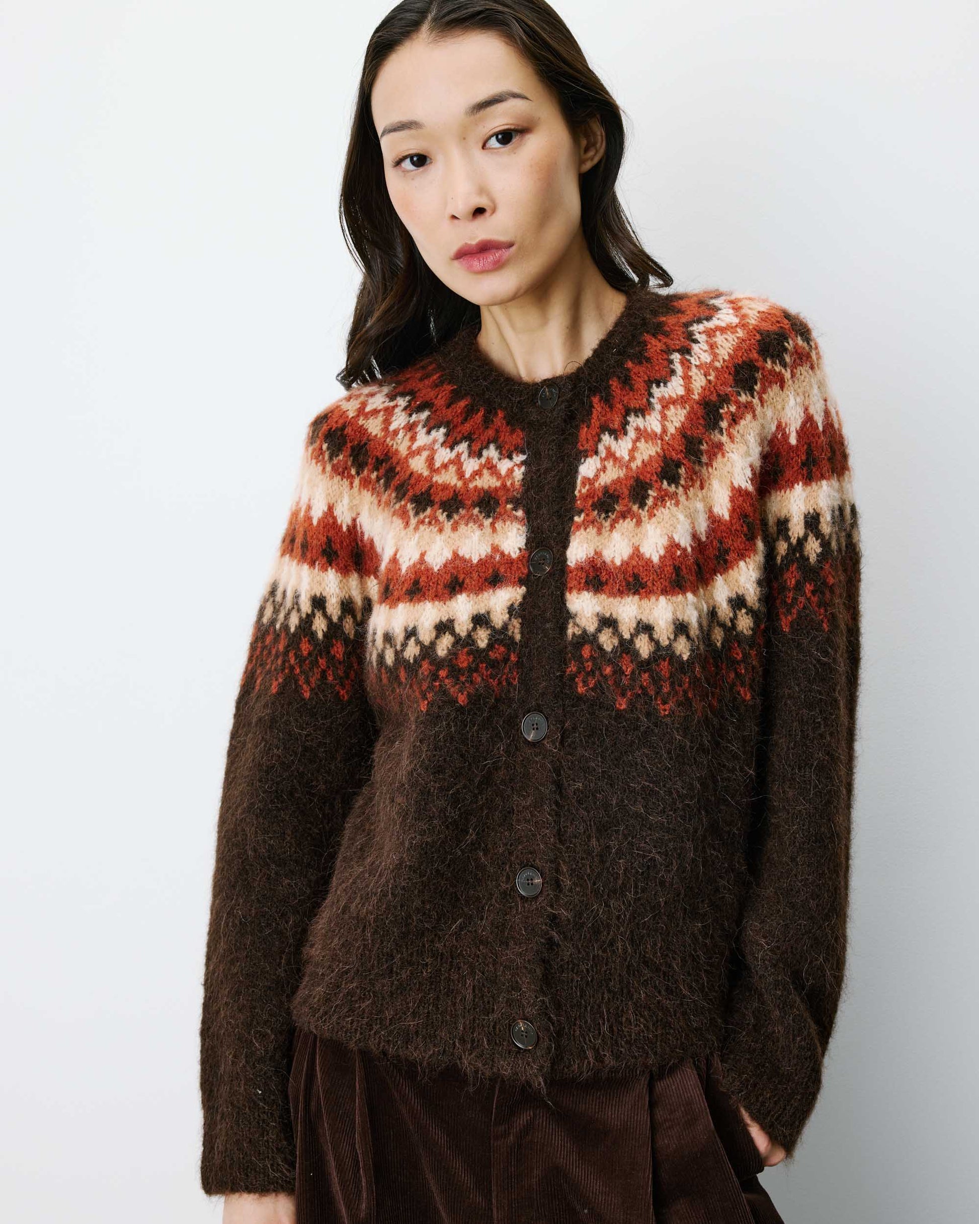 Woman wearing a patterned sweater against a plain background