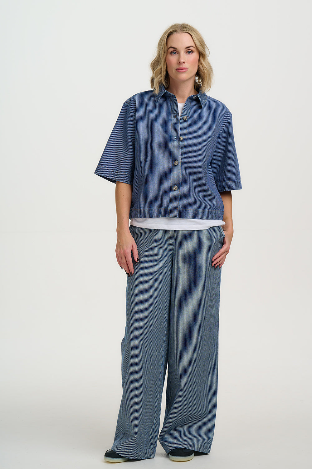 Woman wearing a blue denim outfit on a white background
