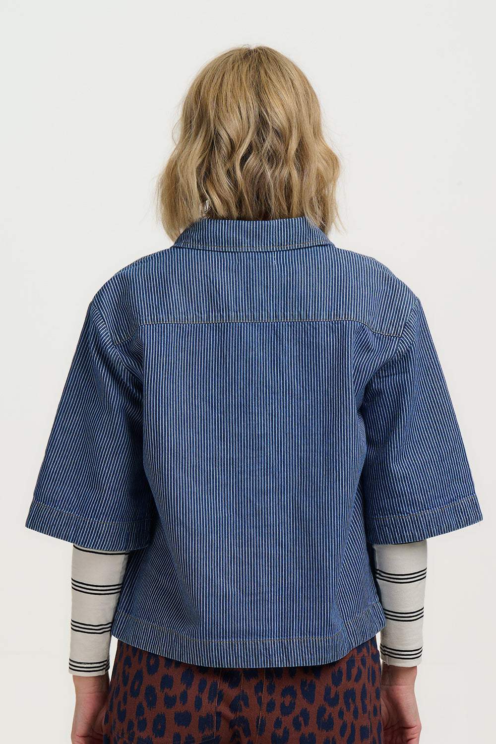 Person wearing a blue striped shirt with a white background