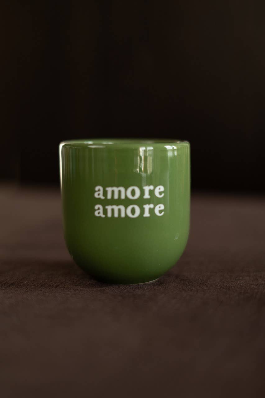Green mug with 'amore amore' text on a dark background