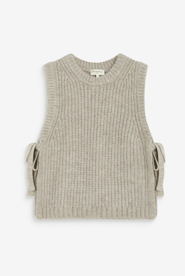 A sleeveless ribbed knit vest in a light beige or oatmeal color, featuring side tie details, shown on a white background within a mobile browser screenshot.