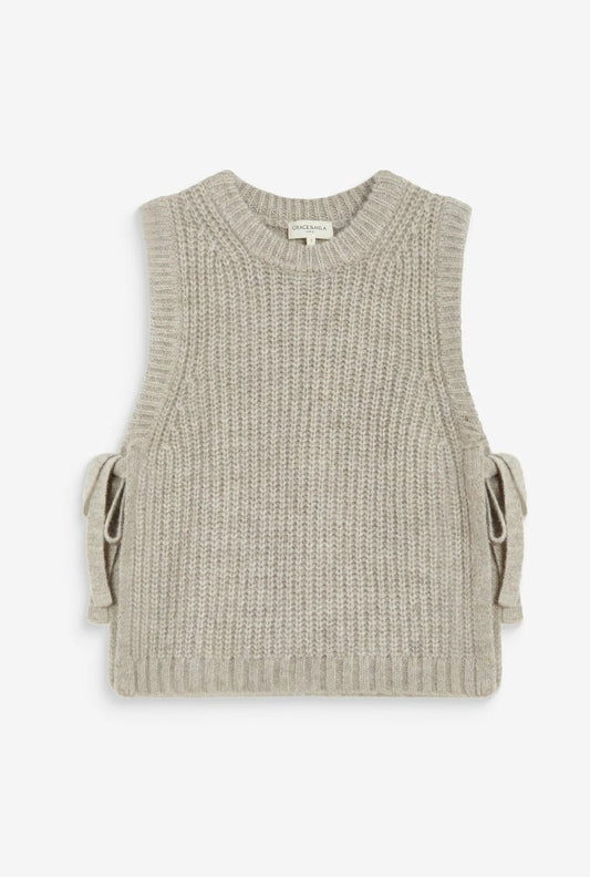 A sleeveless ribbed knit vest in a light beige or oatmeal color, featuring side tie details, shown on a white background within a mobile browser screenshot.