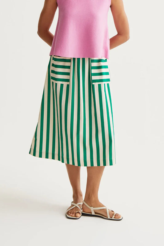 Person wearing a pink top and green and white striped skirt on a white background