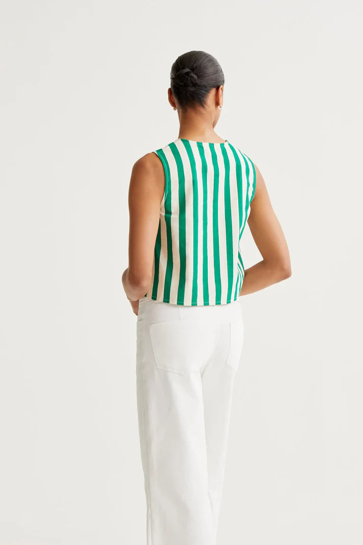Person wearing a green and white striped sleeveless top and white pants on a white background
