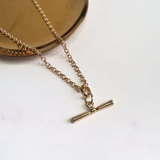 Gold necklace with a pendant on a white background