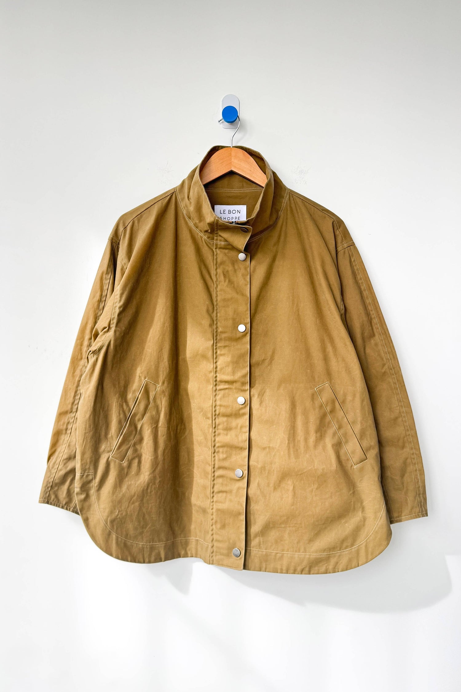Brown jacket on a hanger against a white background