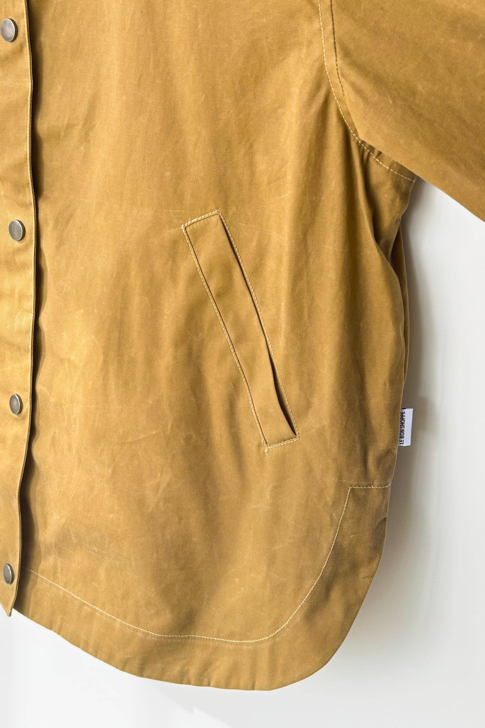 Close-up of a mustard yellow shirt with a pocket on a white background