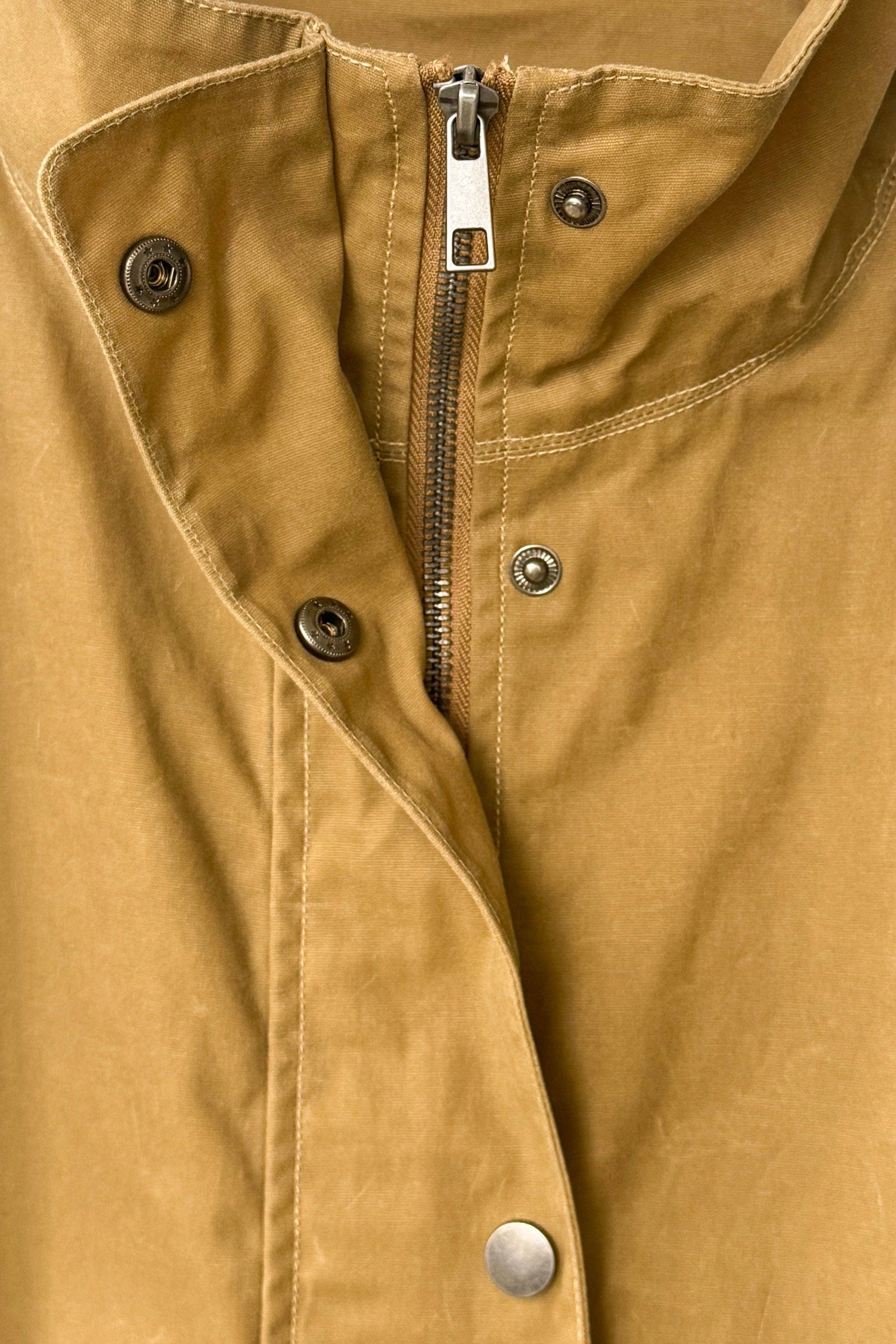 Close-up of a brown jacket with buttons and a zipper