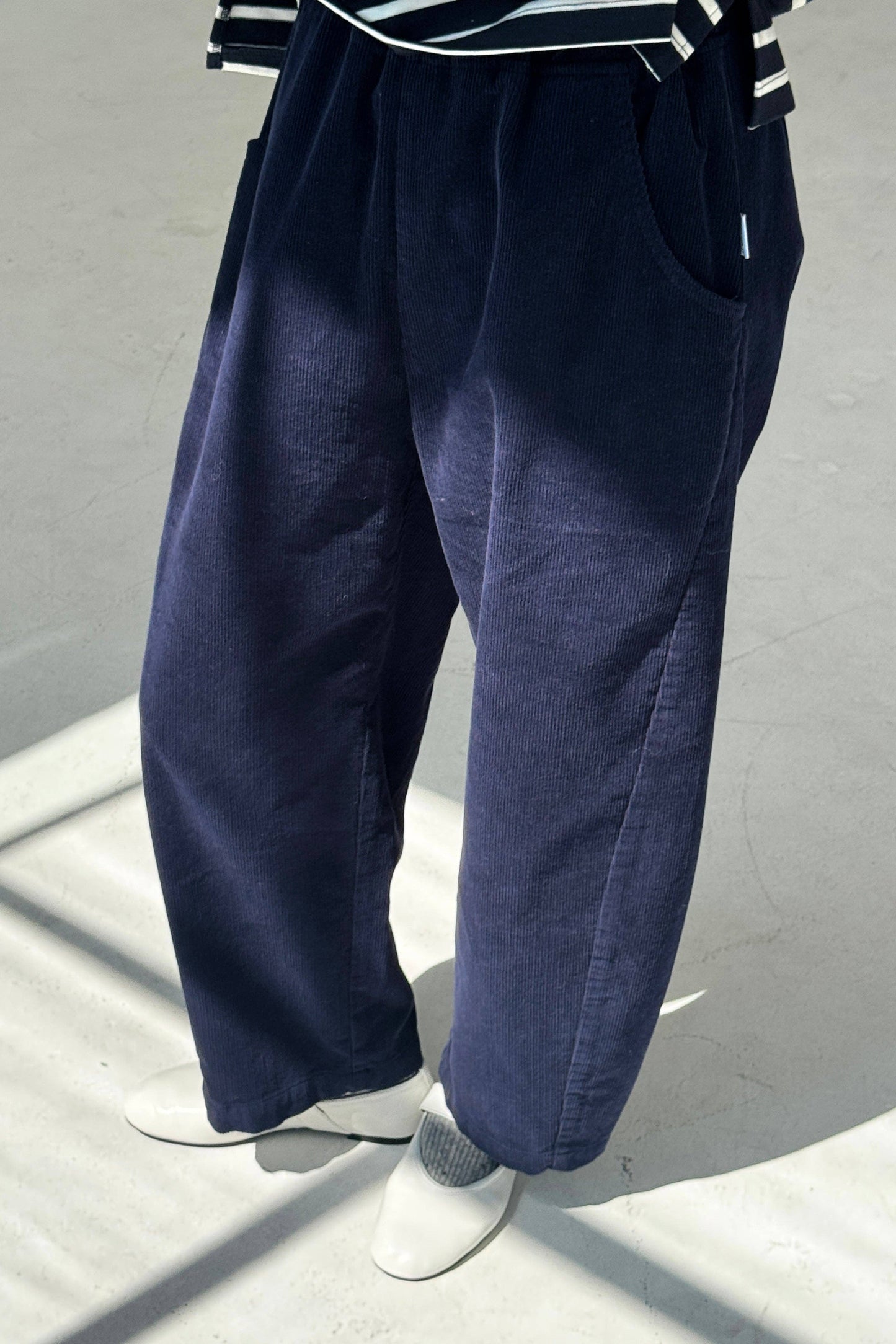 Navy blue wide-leg pants worn by a person on a light gray background