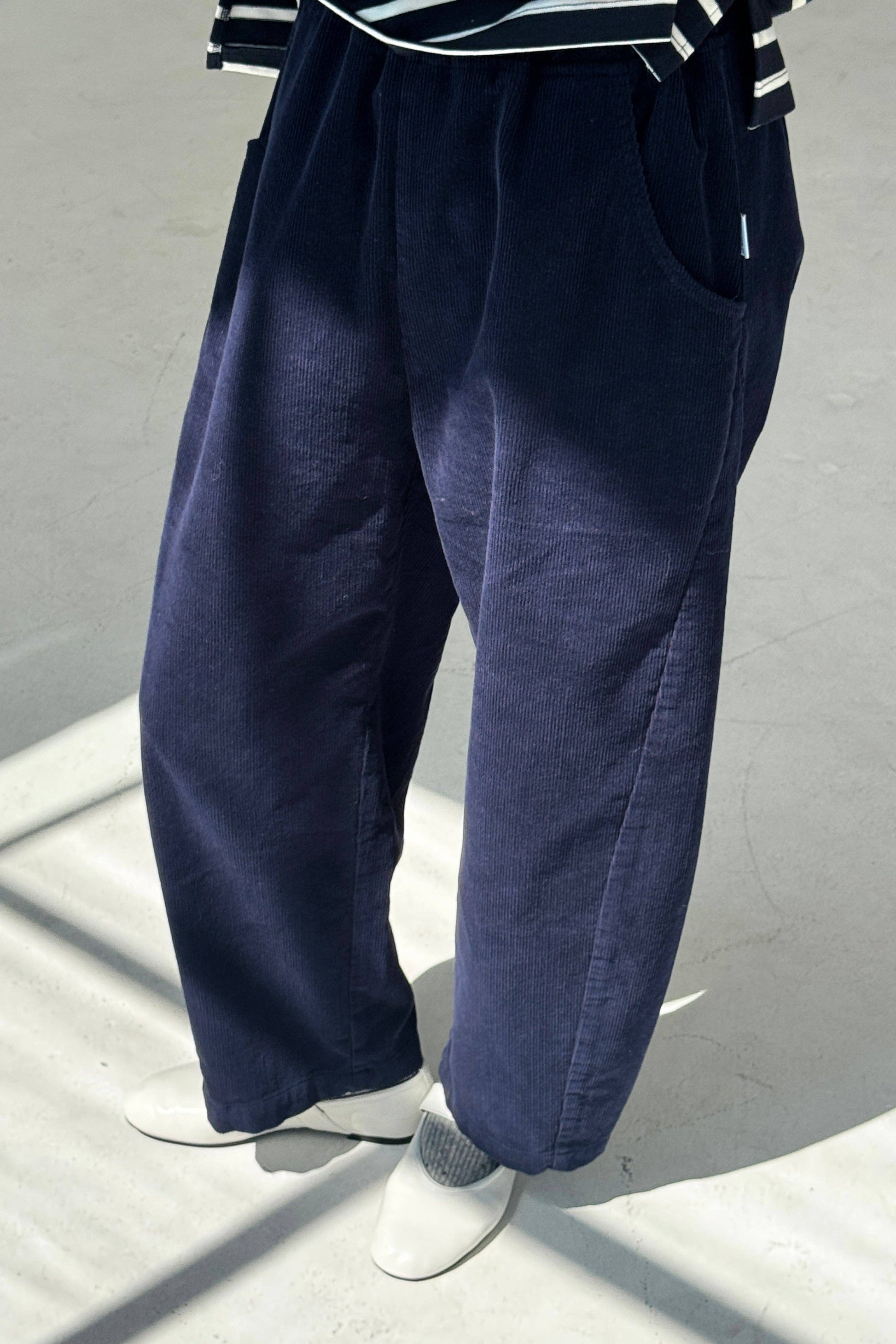 Navy blue wide-leg pants worn by a person on a light gray background