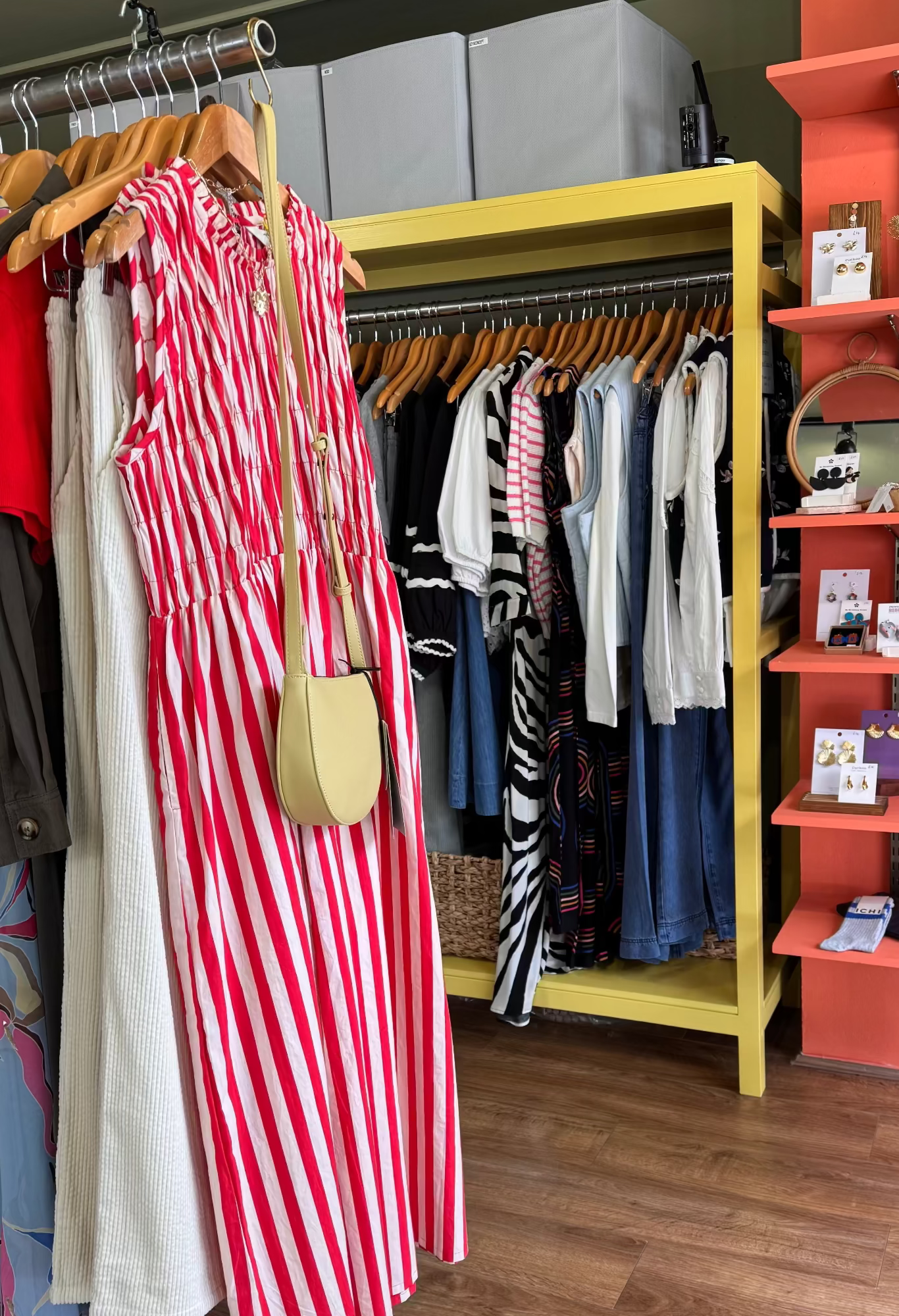 Clothing store interior with racks of clothes and a display shelf.