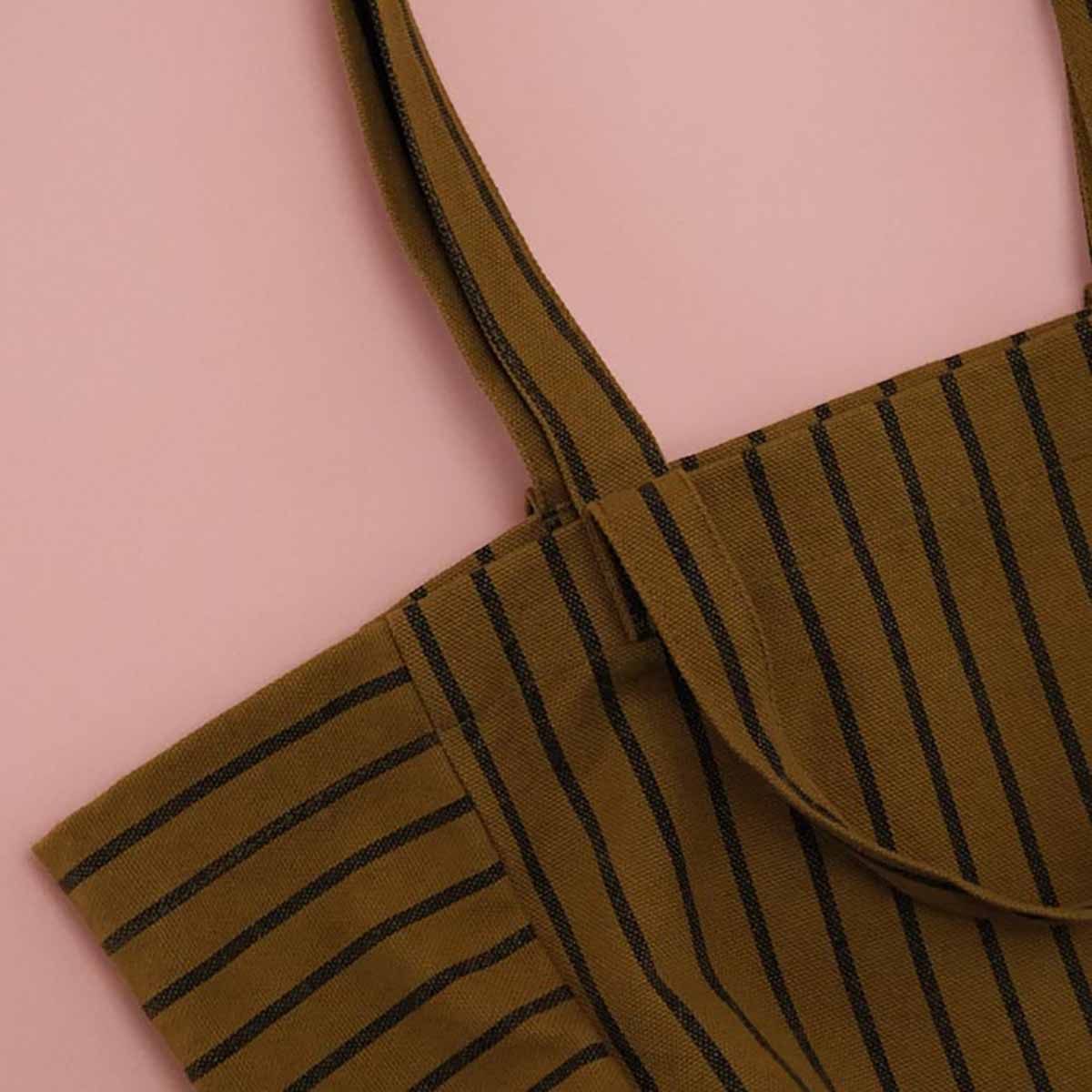 Brown apron with black stripes on a pink background