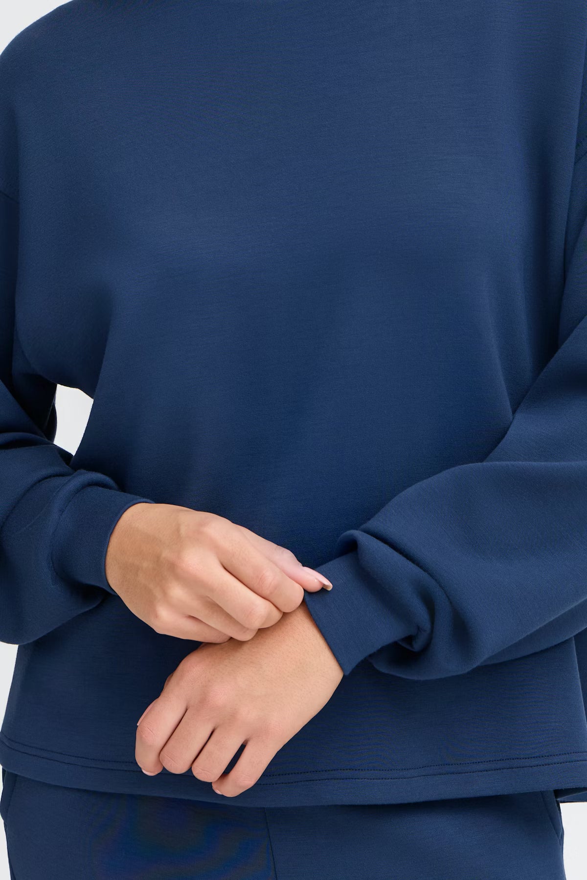 Person wearing a blue outfit with a close-up of the arm and hand.