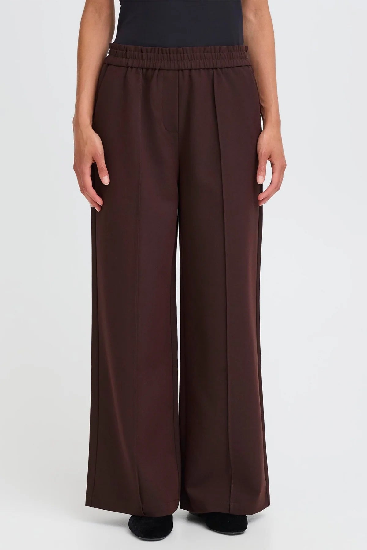 Brown wide-leg pants worn by a person on a white background
