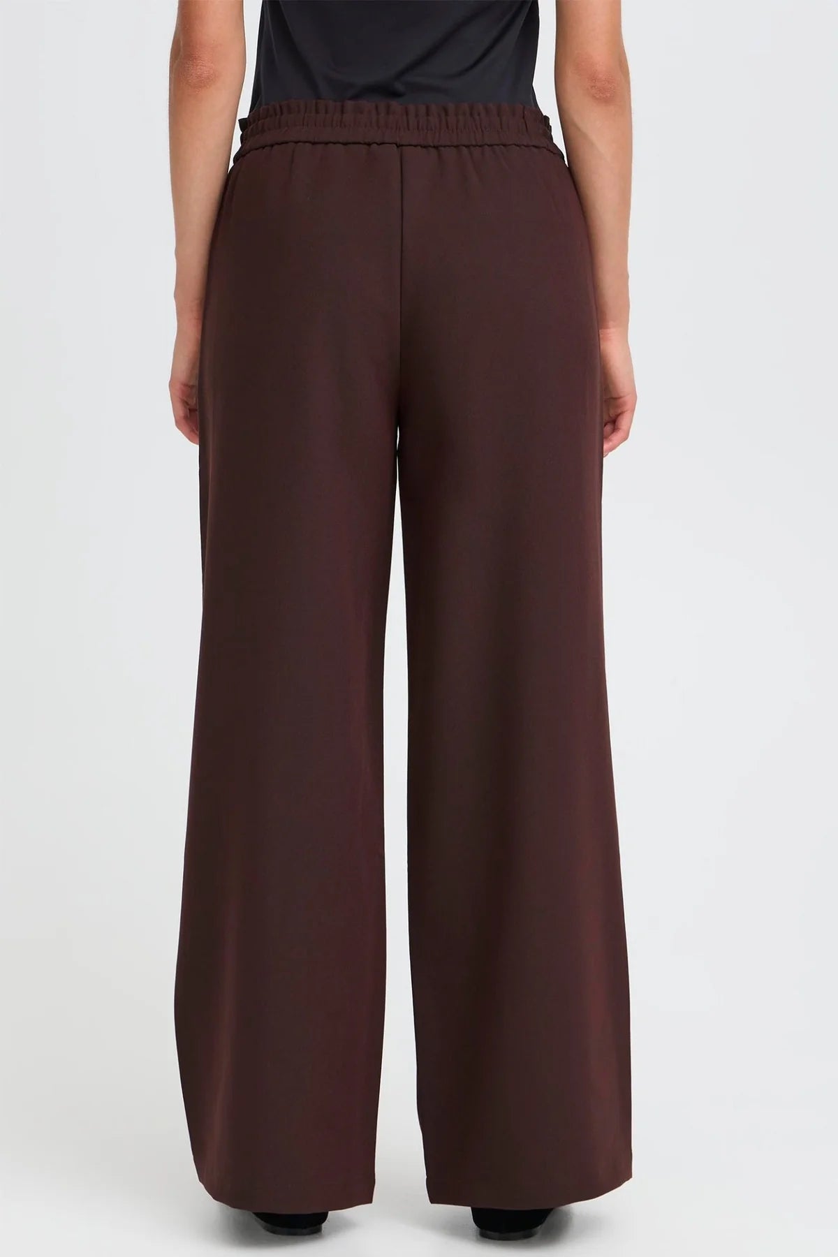 Brown wide-leg pants worn by a person on a white background
