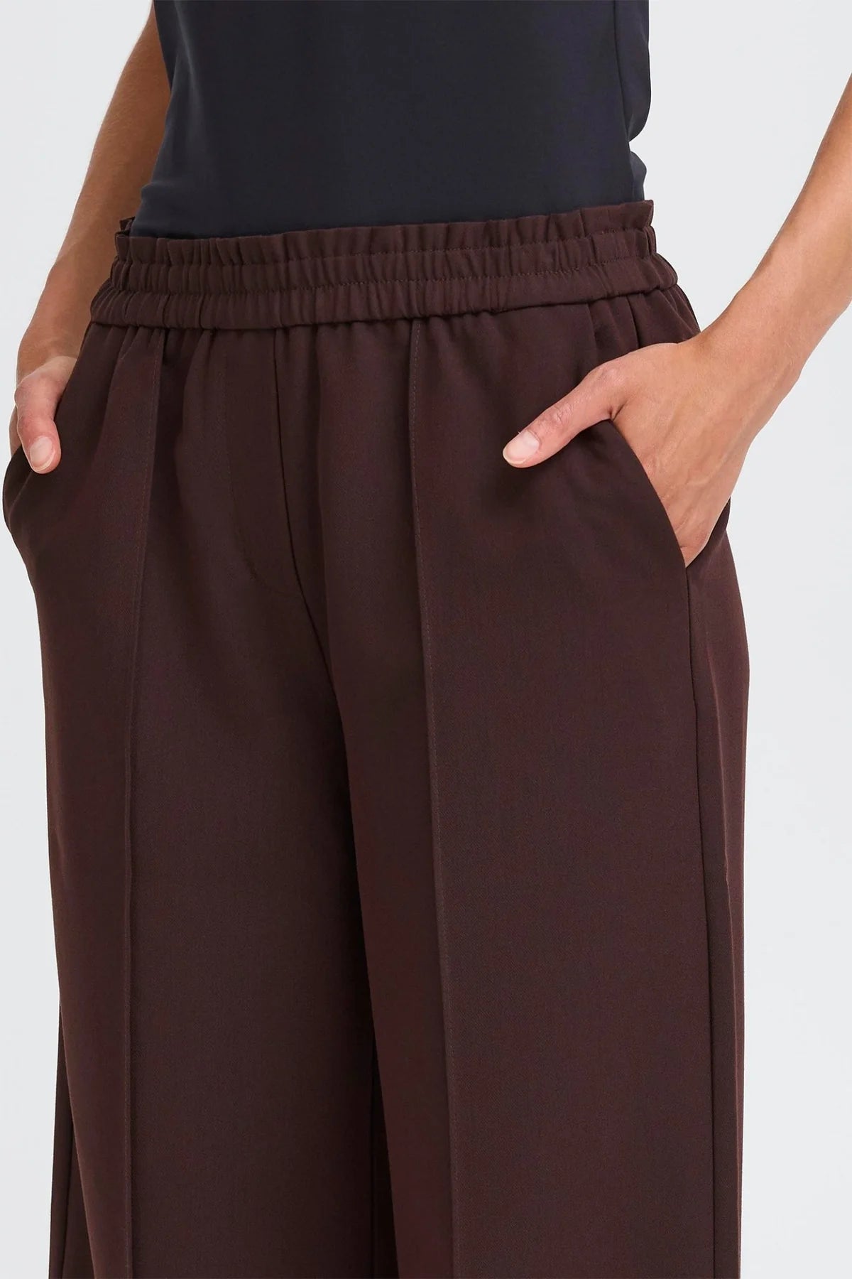 Brown wide-leg pants worn by a person on a white background