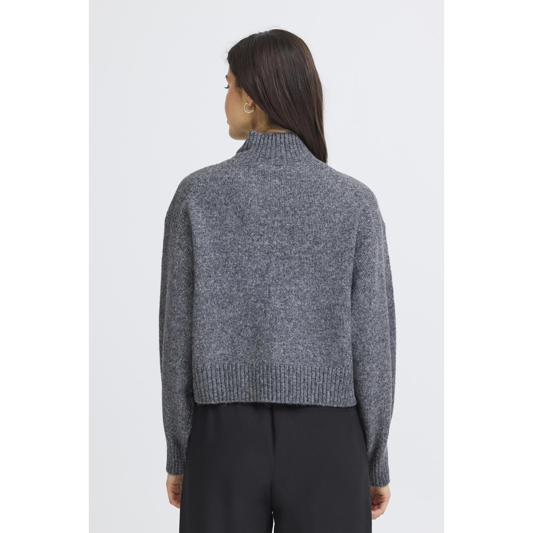 Person wearing a gray knit sweater on a white background