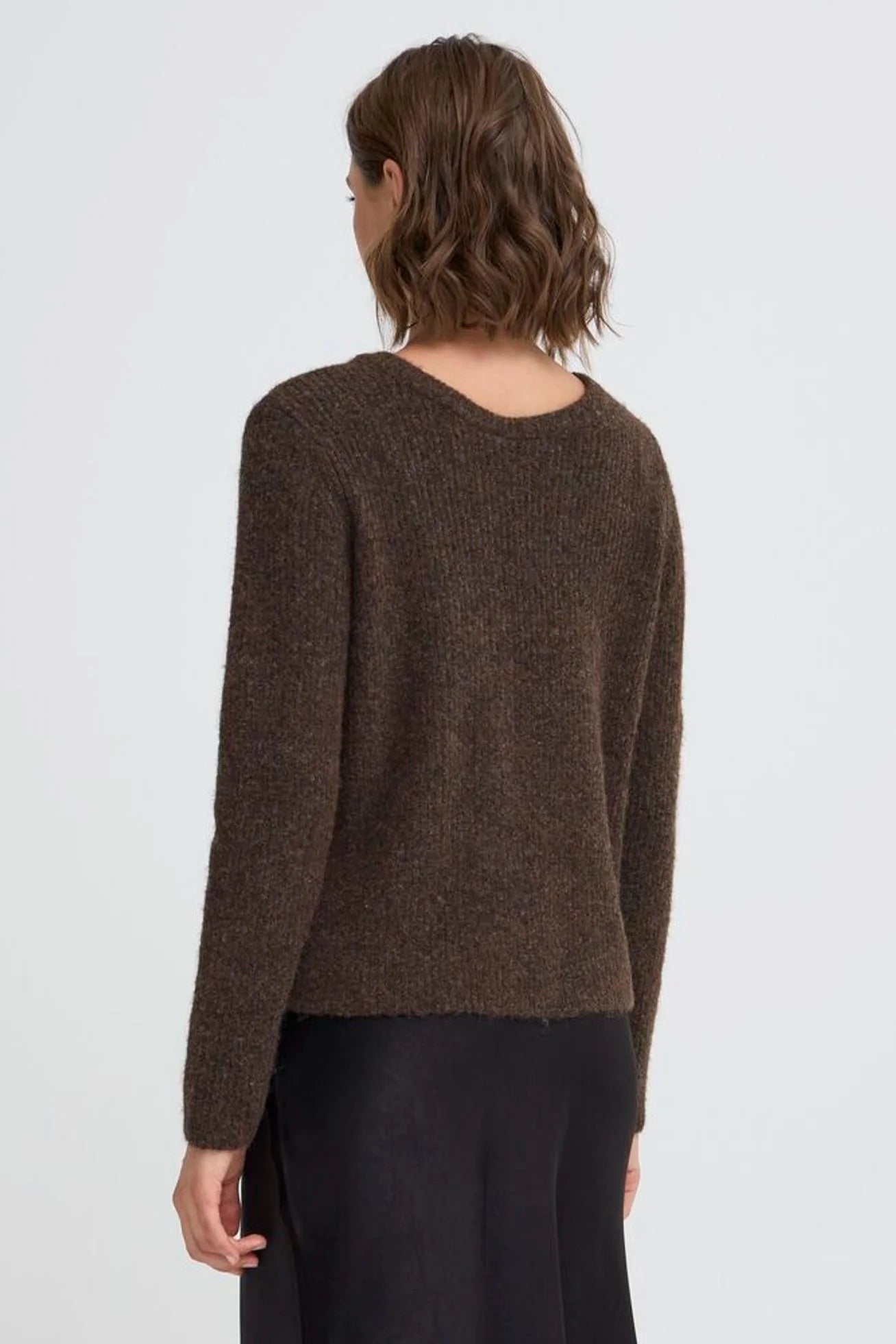 Person wearing a brown sweater on a white background