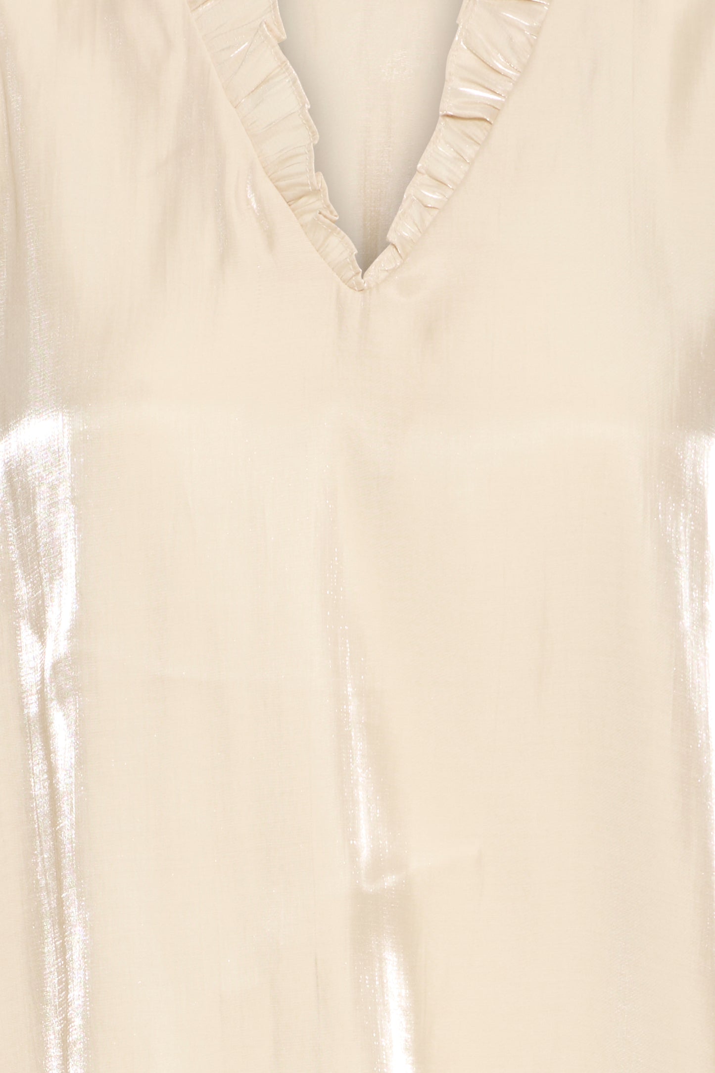 Close-up of a beige blouse with ruffled neckline