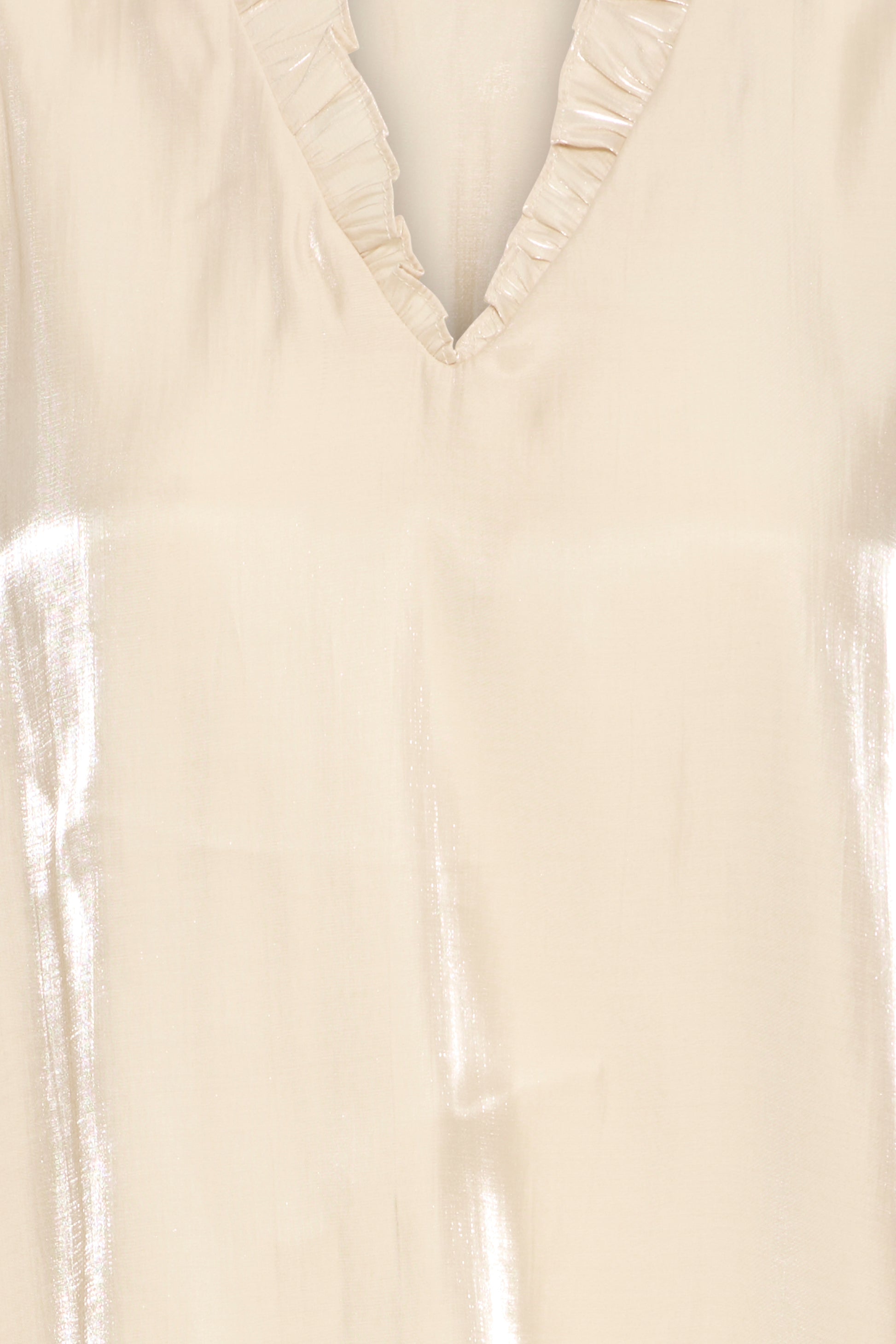 Close-up of a beige blouse with ruffled neckline