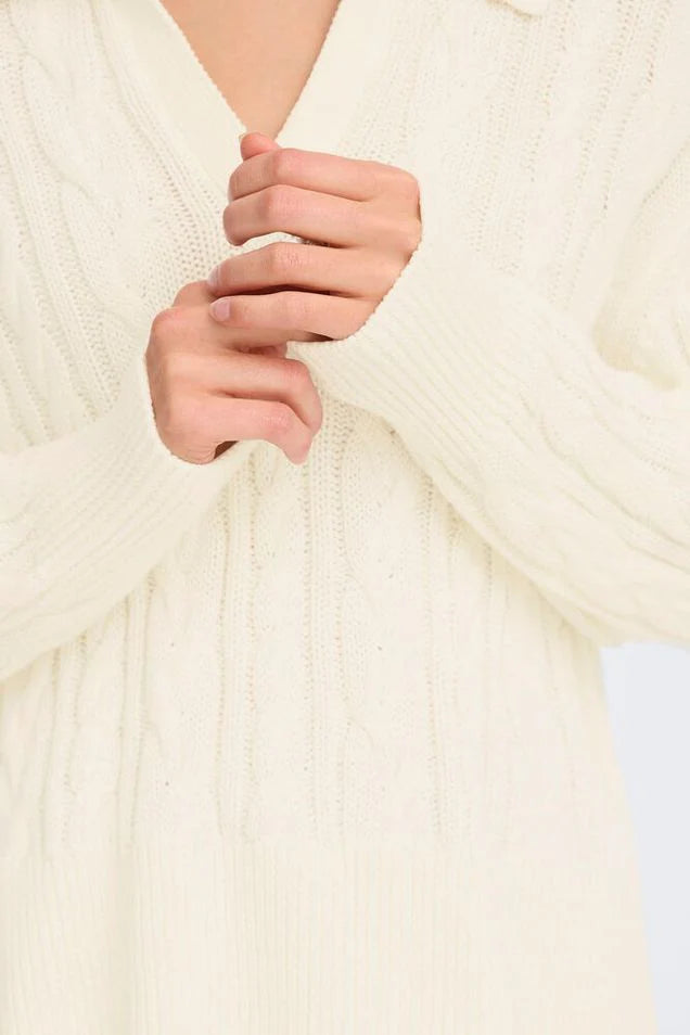 Person wearing a cream cable knit pullover