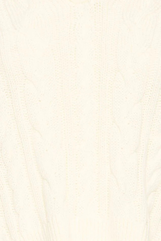 close up of a cream cable knit pullover