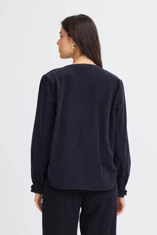 Person wearing a black long-sleeve top and pants on a white background