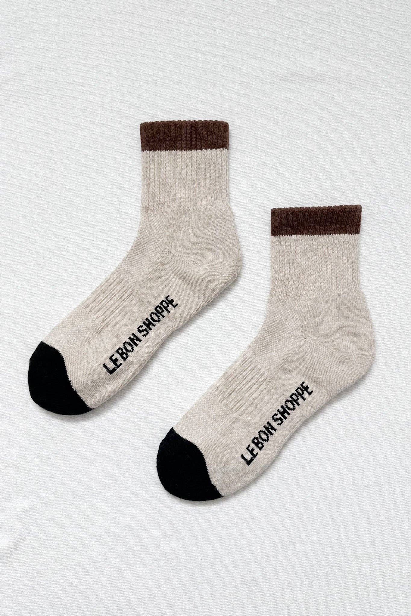 Pair of socks with brown cuffs and black toes on a white background
