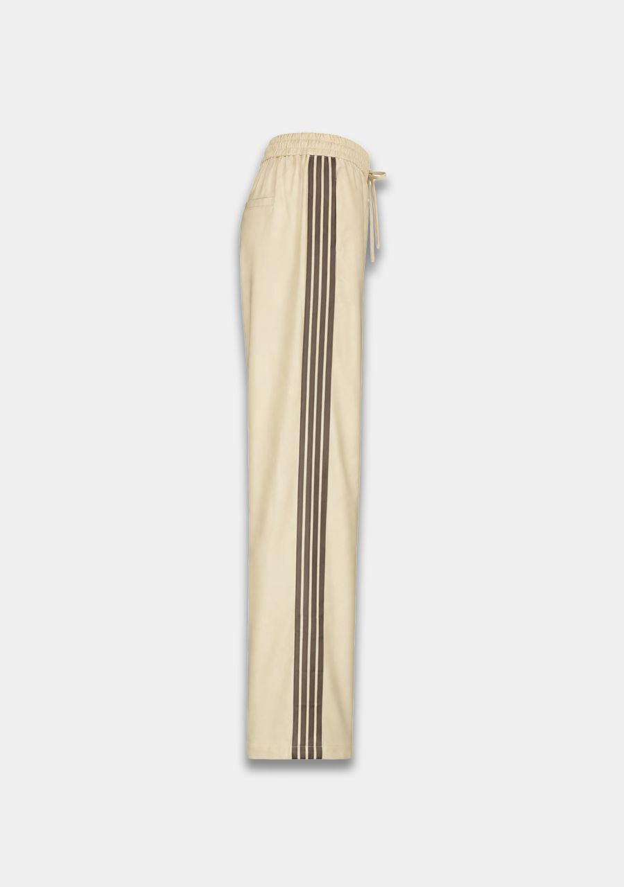 Beige wide-leg track pants featuring three dark brown stripes down the side, shown against a light gray background.