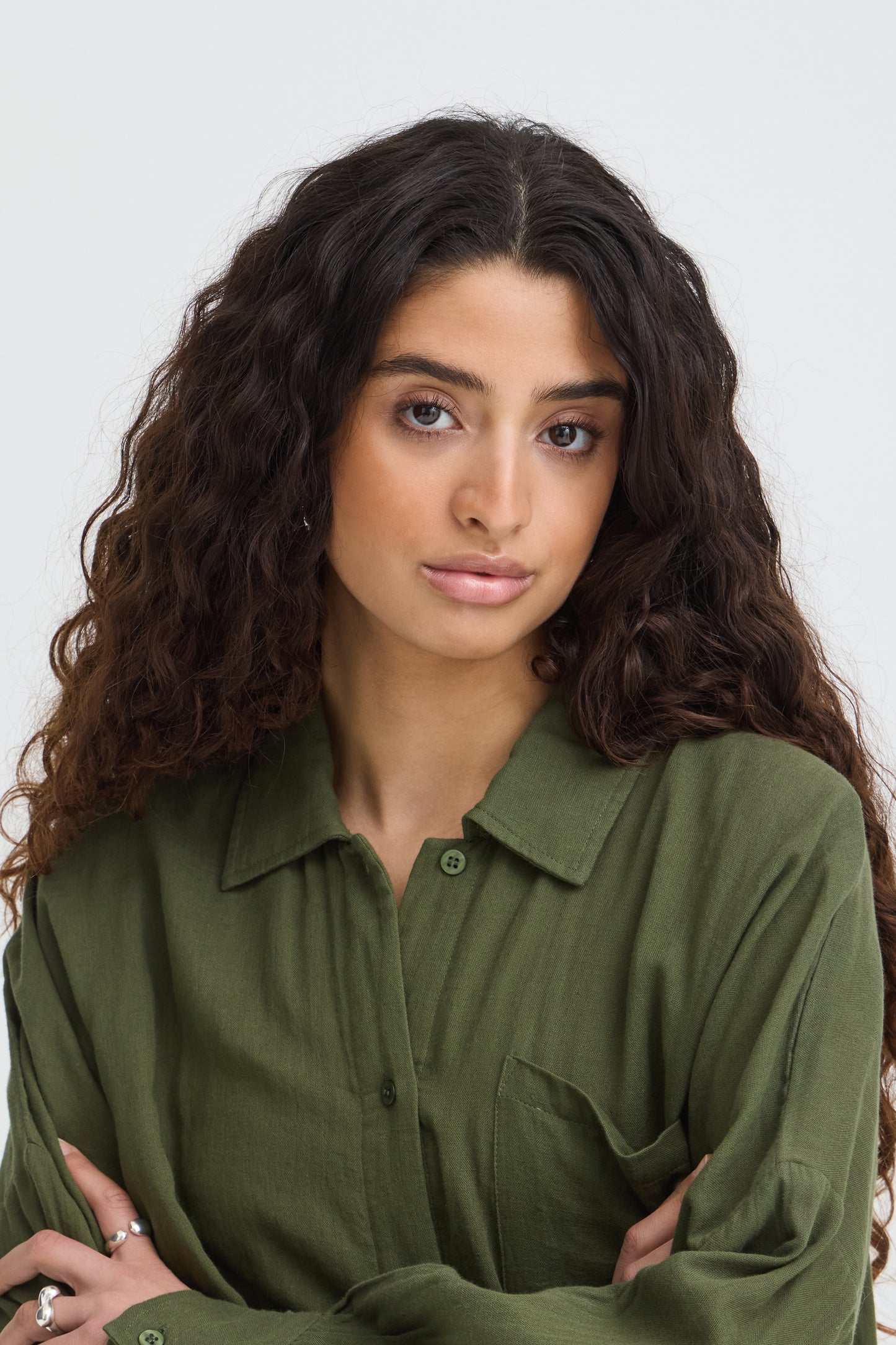 Woman wearing a green shirt against a plain background