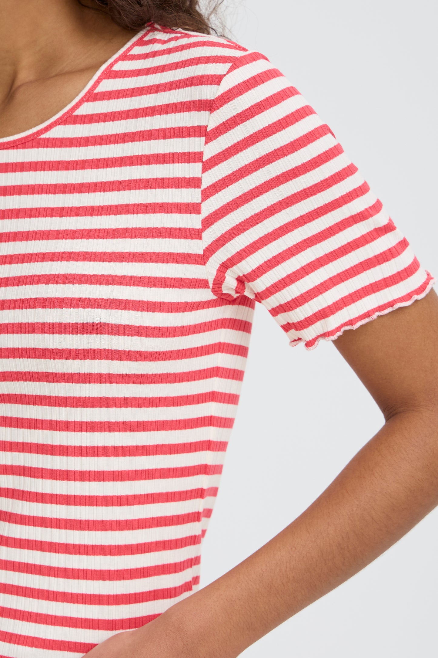 Red and white striped shirt worn by a person on a light gray background