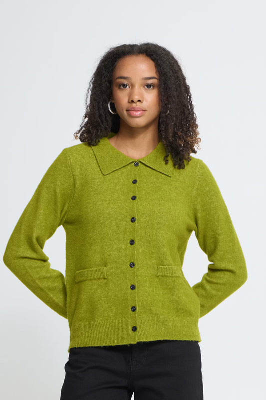 Woman wearing a green cardigan with black buttons on a white background