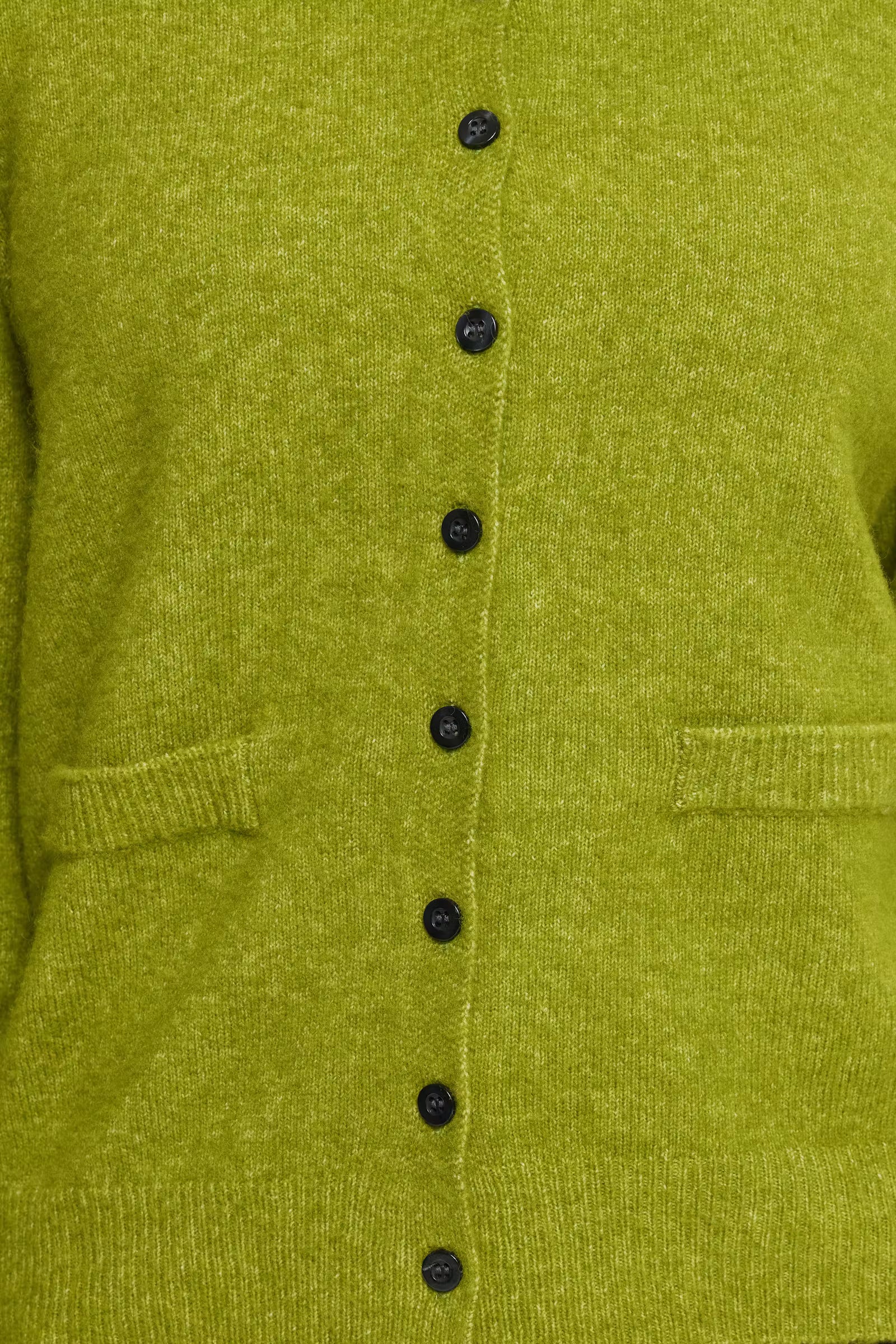 Close-up of a textured olive green knit cardigan featuring a vertical row of black buttons down the center front and ribbed trim.