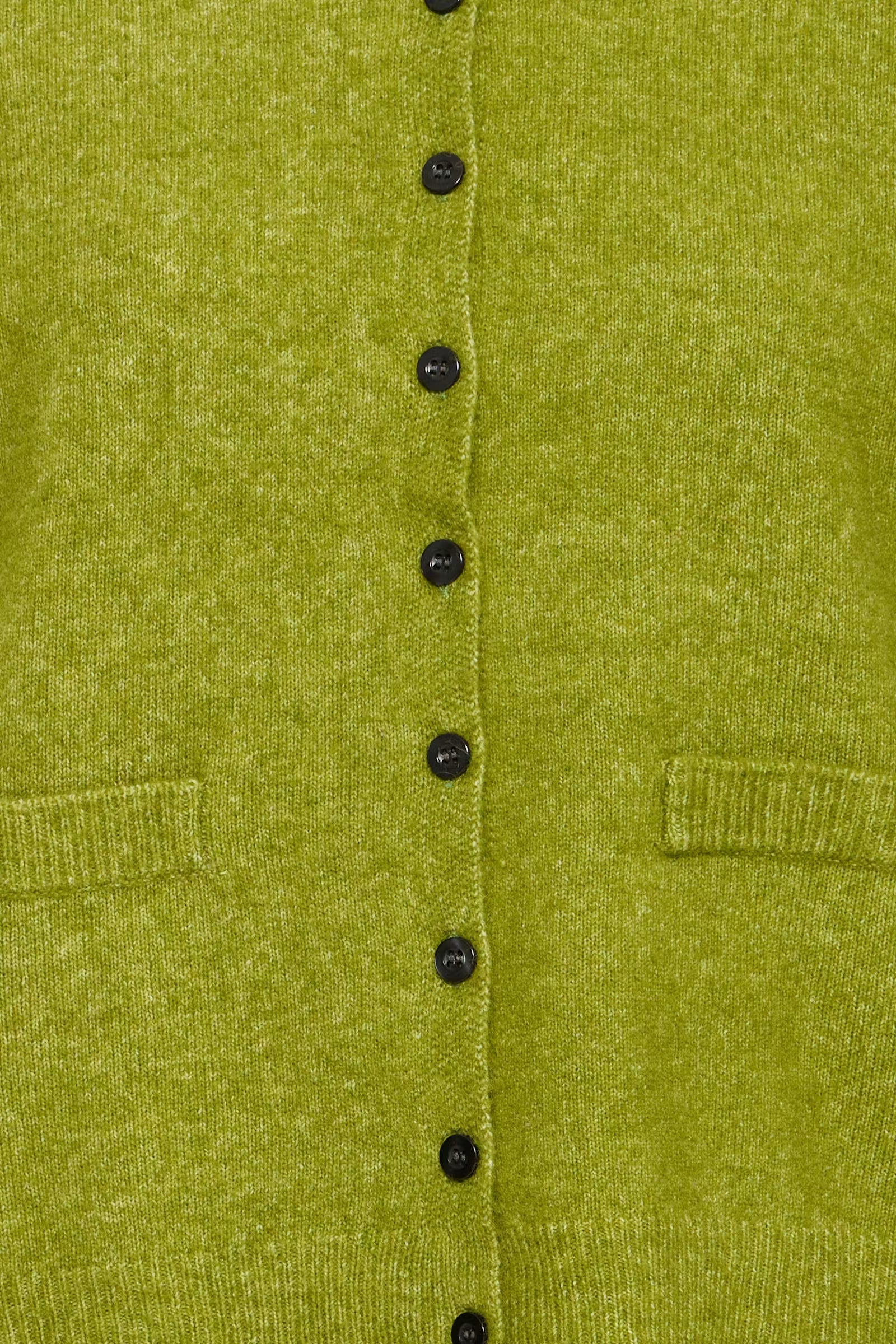 Close-up of a textured olive green knit cardigan featuring a vertical row of black buttons and two front patch pockets.