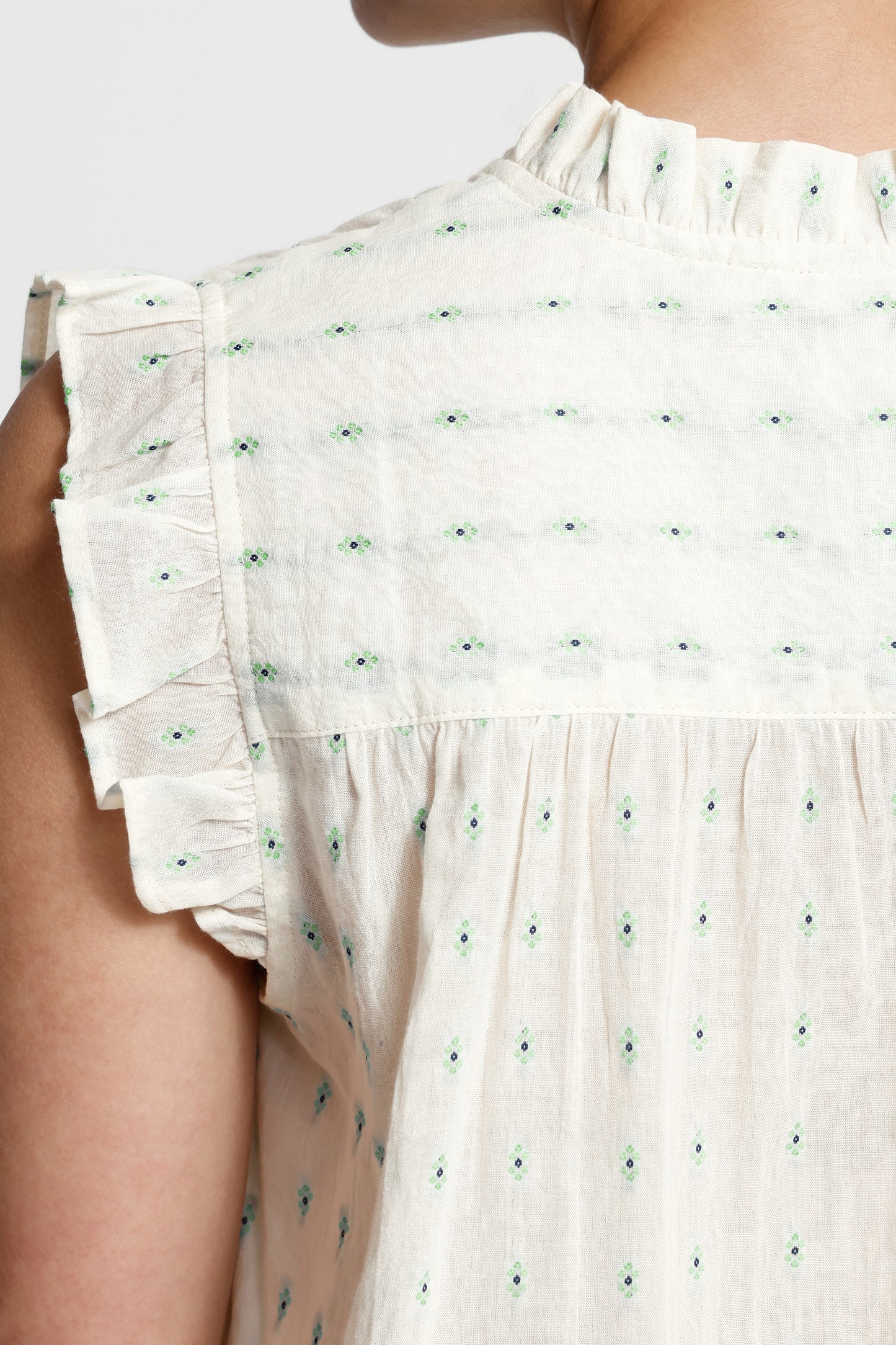 White dress with green floral pattern on a white background