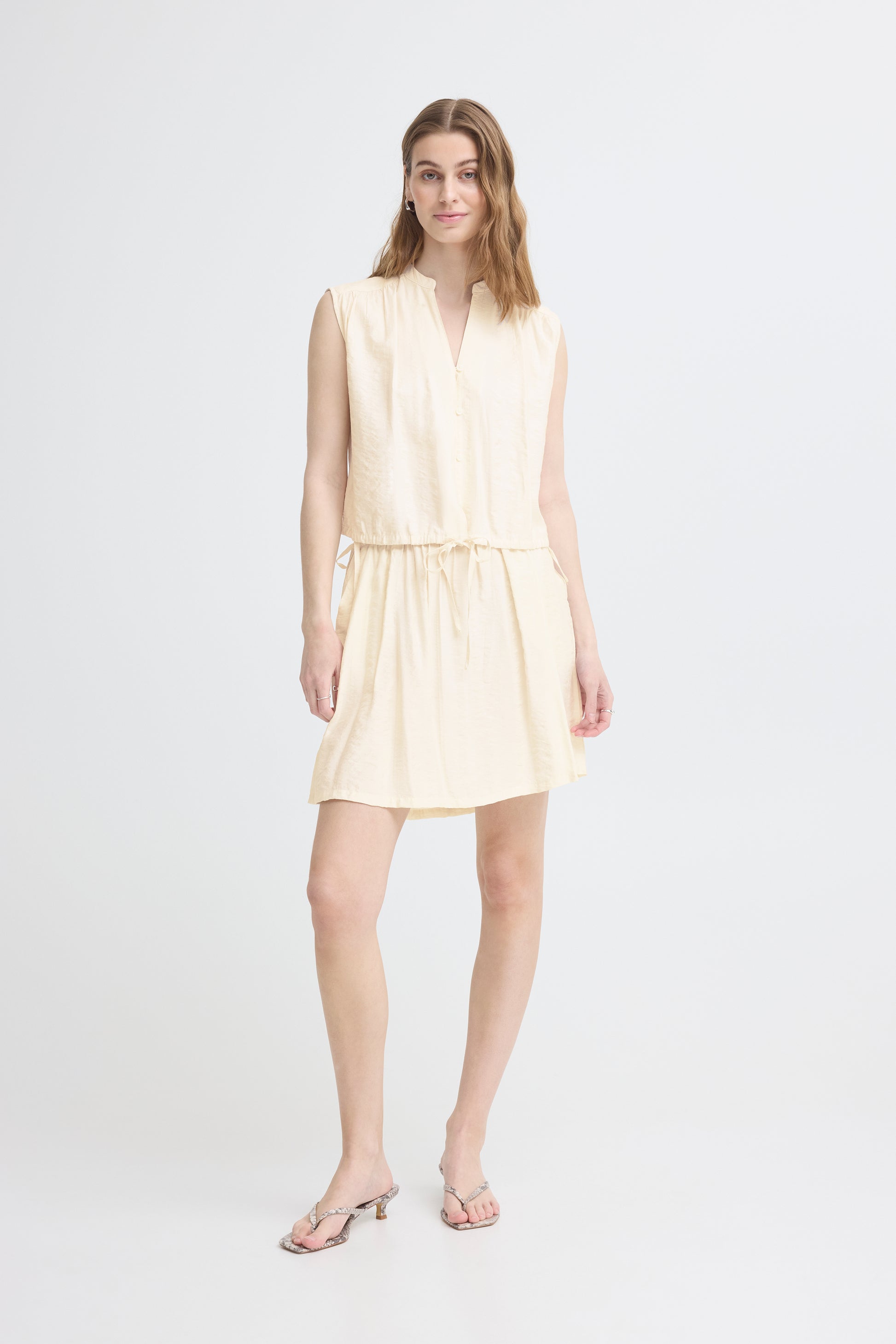 Woman wearing a light yellow dress on a white background