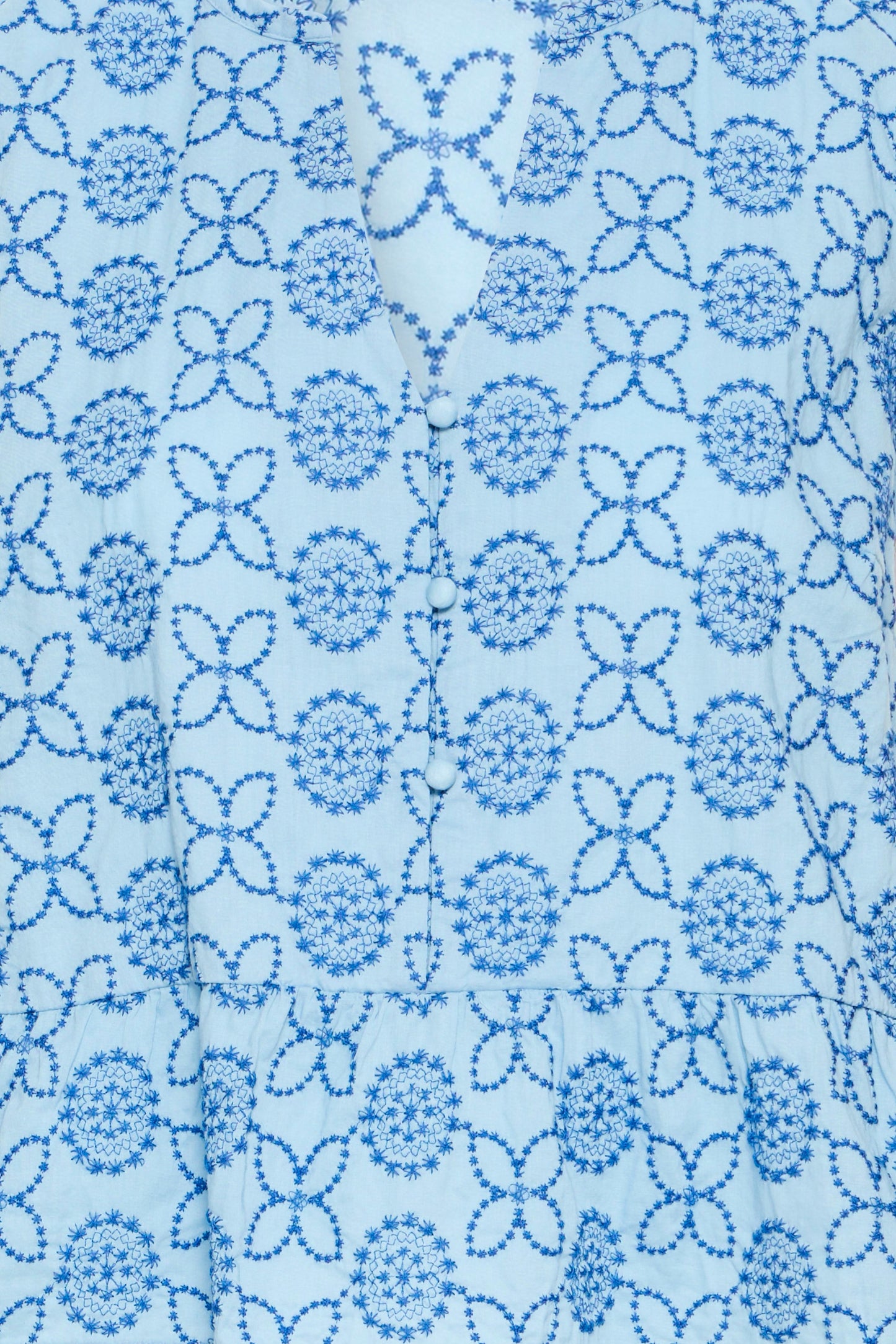 Close-up of a blue floral pattern on a light blue fabric background