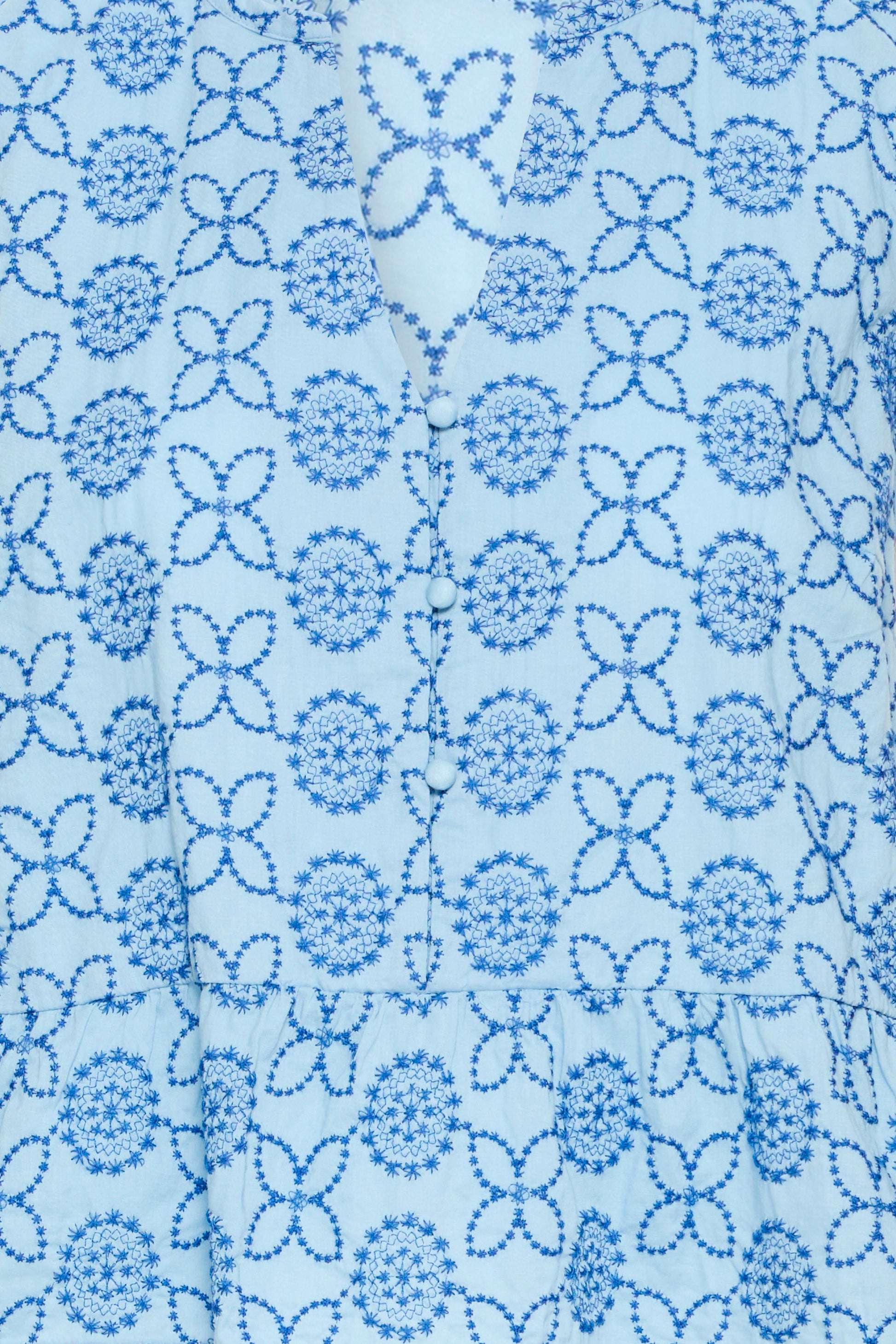 Close-up of a blue floral pattern on a light blue fabric background