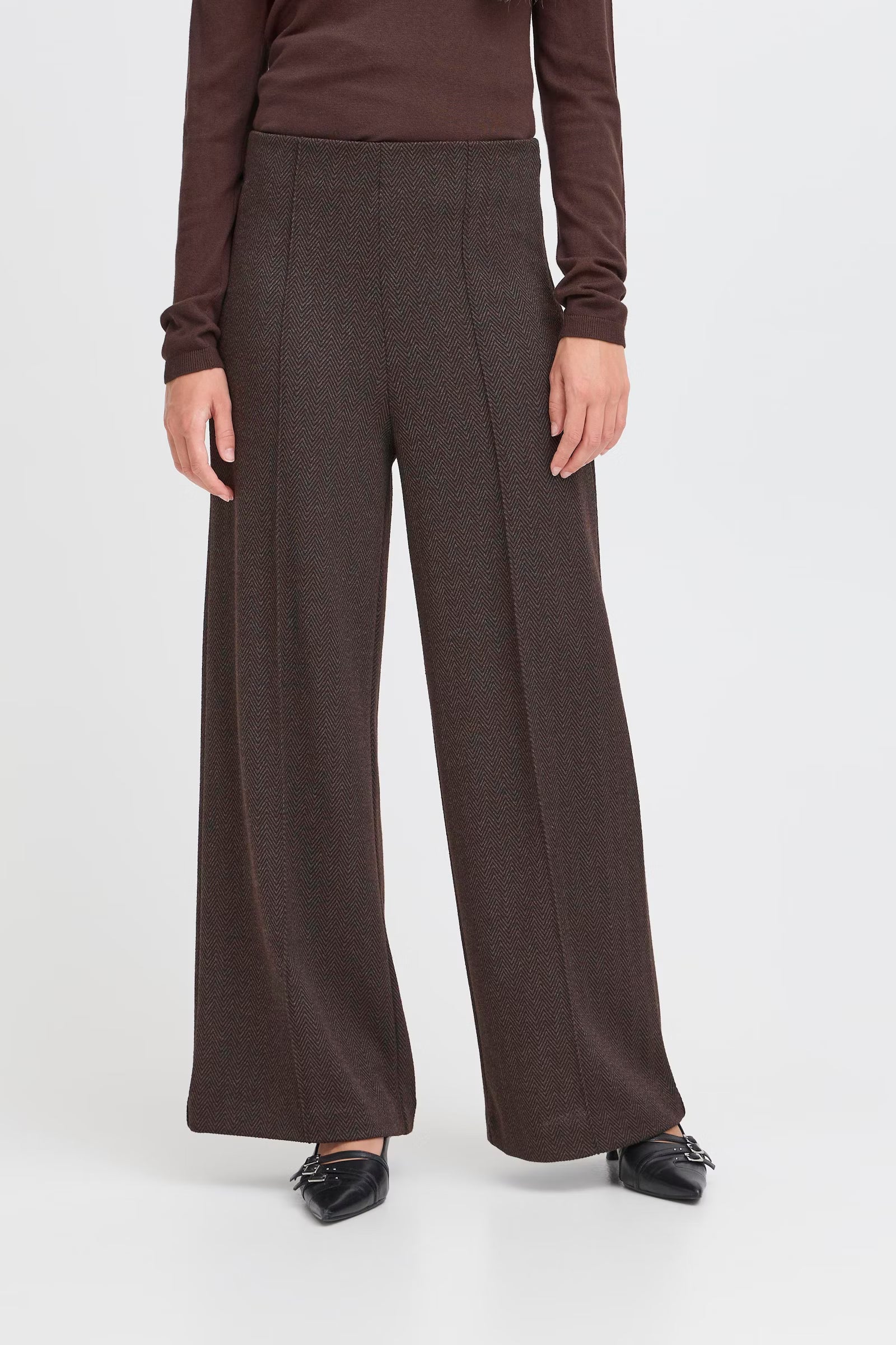 Brown wide-leg pants worn by a person on a white background