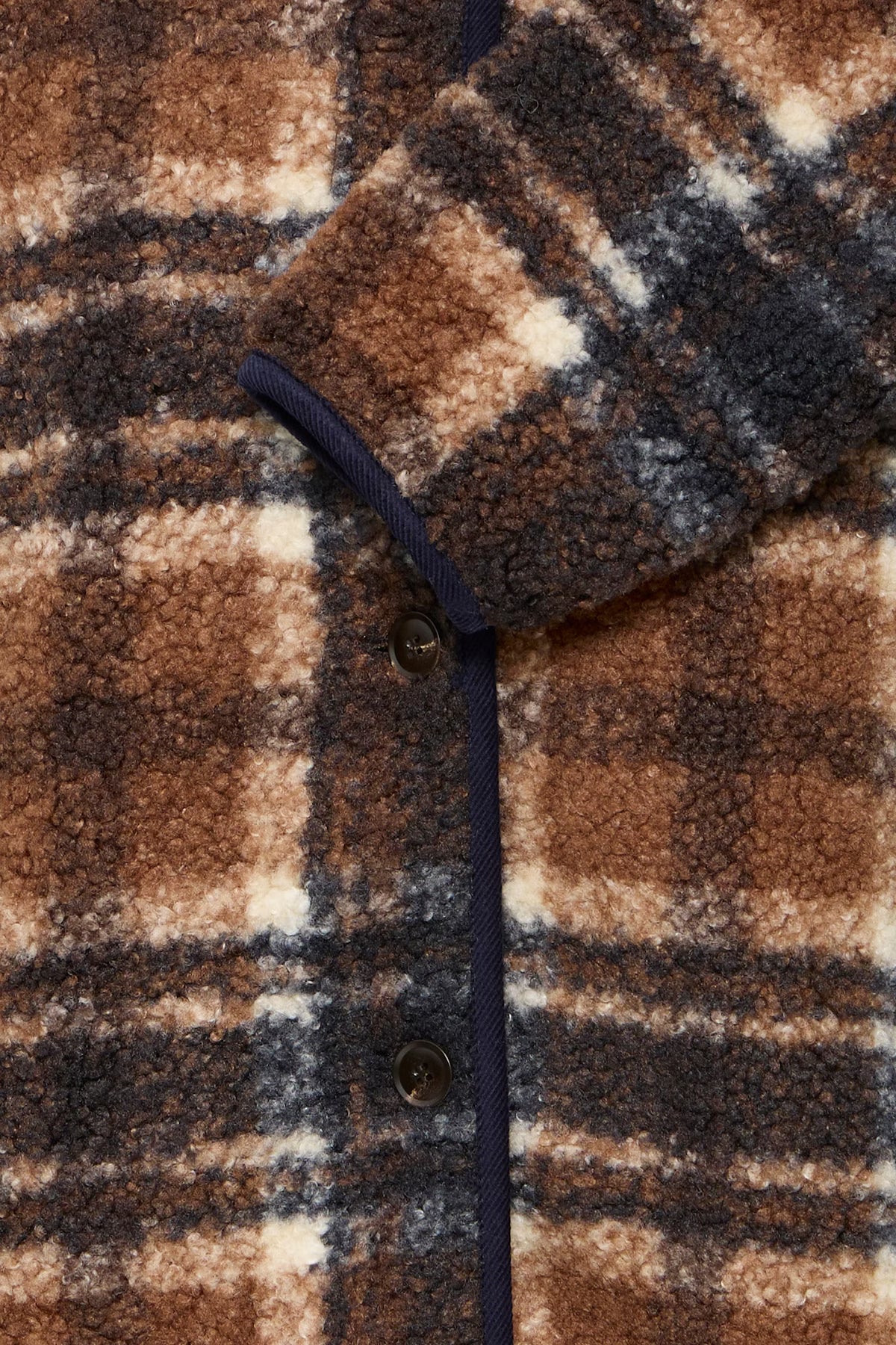 Close-up of a brown and beige plaid fabric with buttons