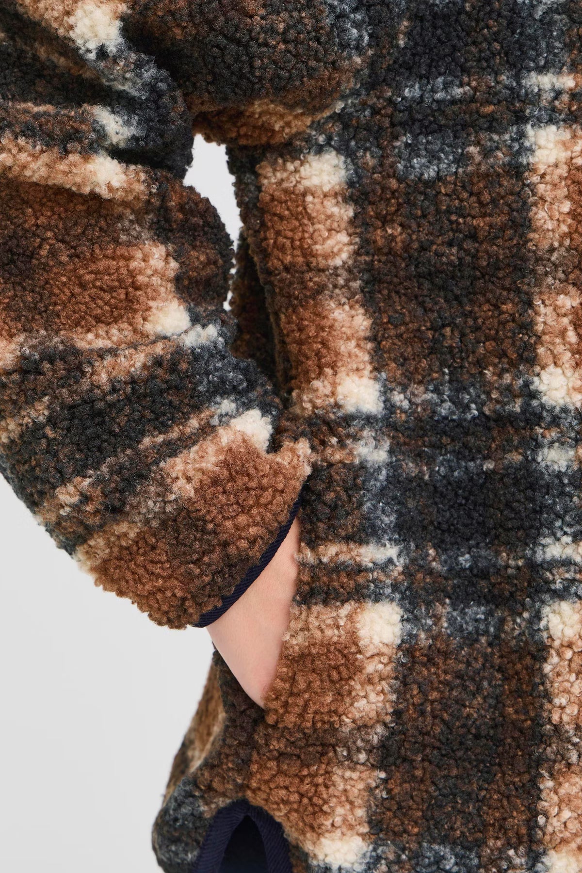 Close-up of a person wearing a plaid robe with a checkered pattern.