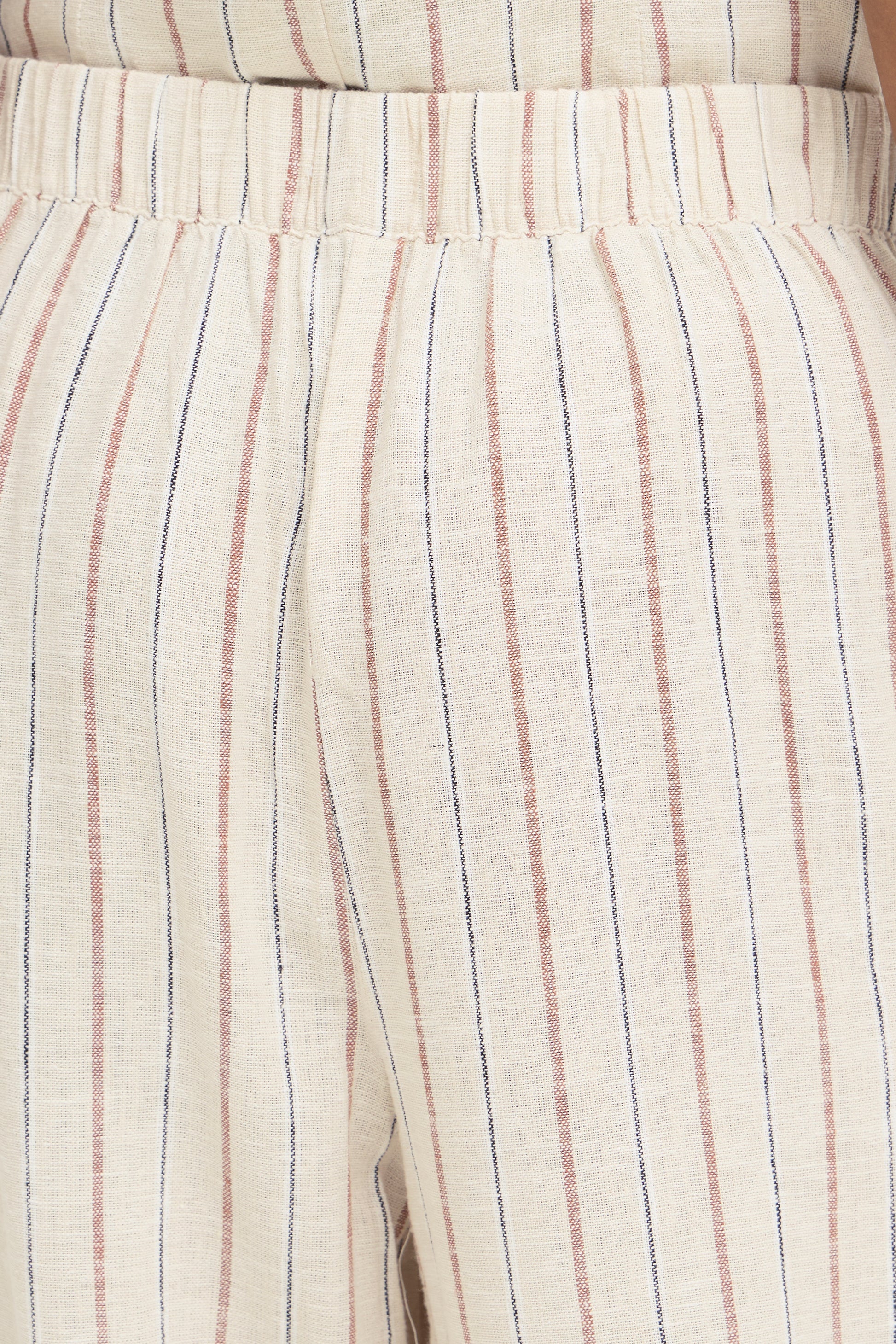 Close-up of beige pants with thin striped pattern