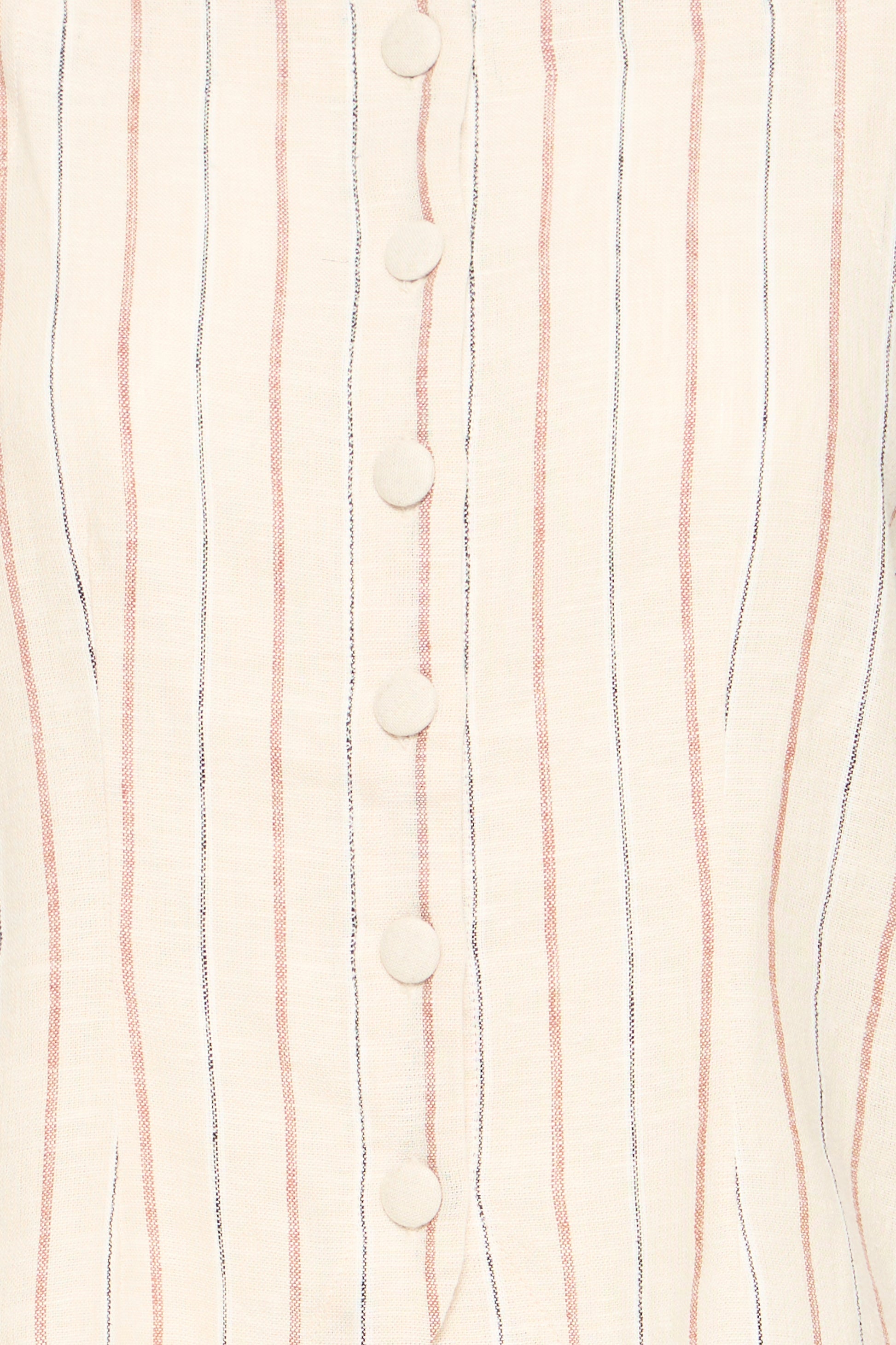 Close-up of a fabric with vertical stripes and buttons on a light background