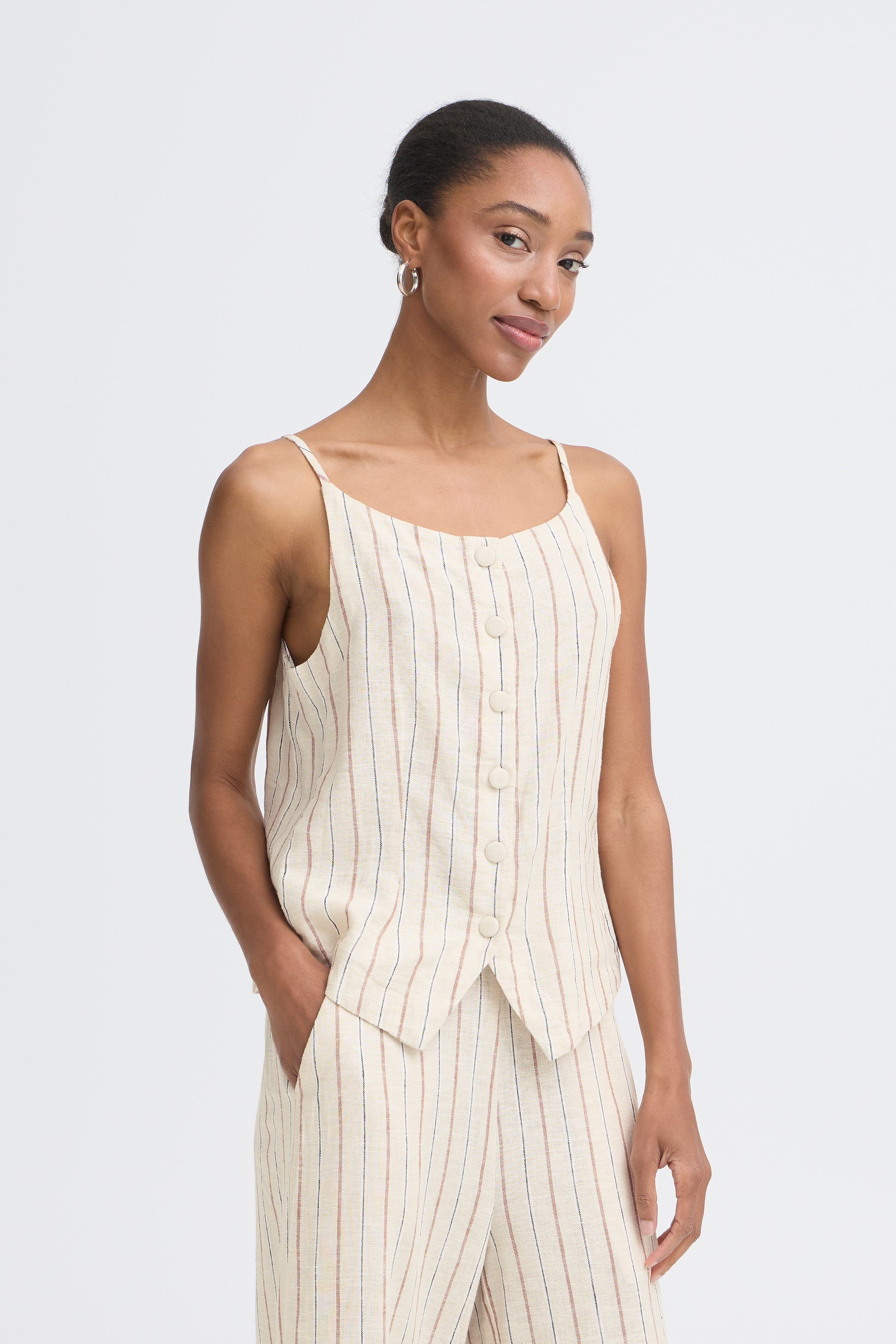 Woman wearing a white pinstripe dress against a plain background