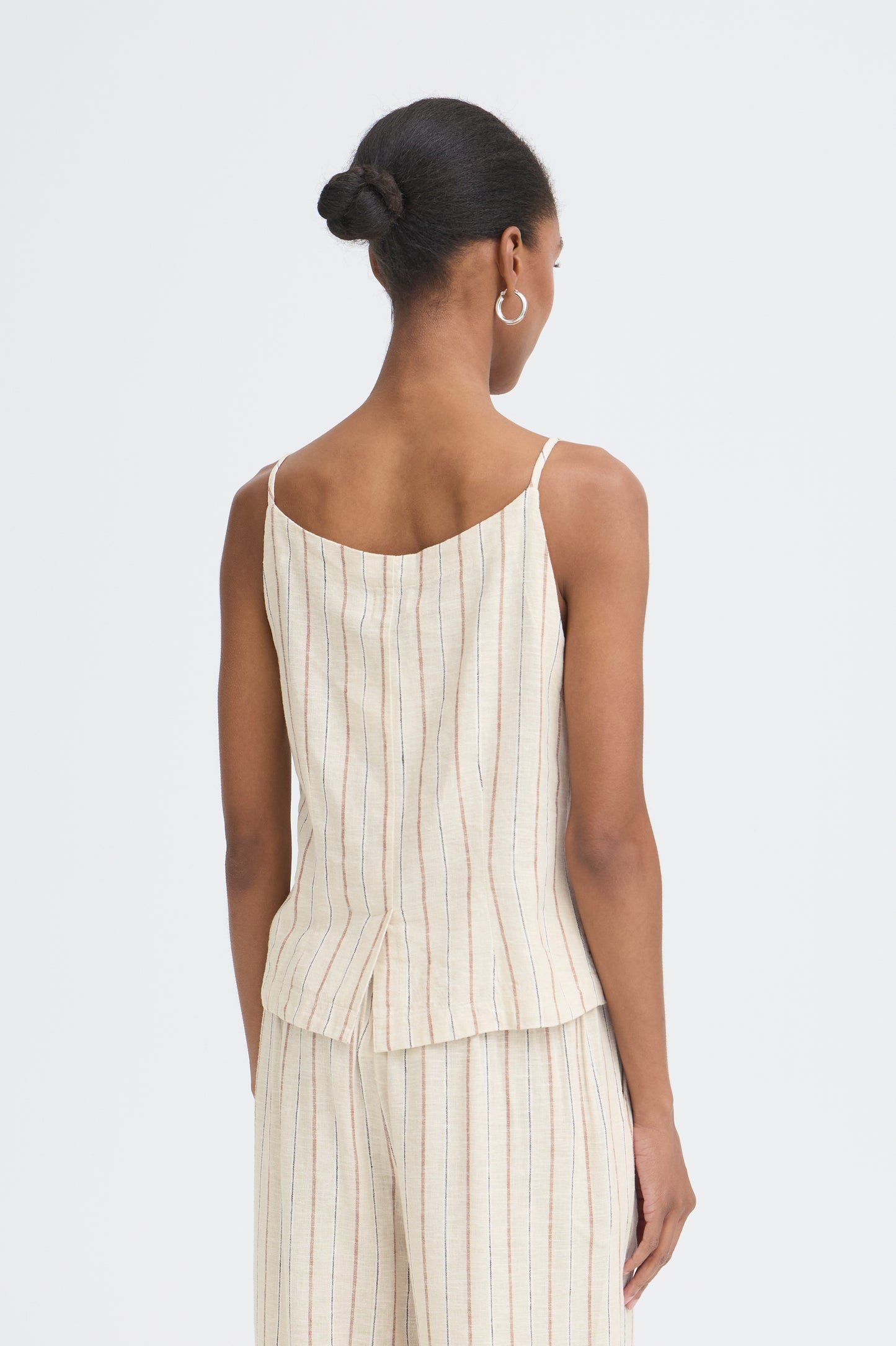 Woman wearing a white pinstripe dress on a light gray background